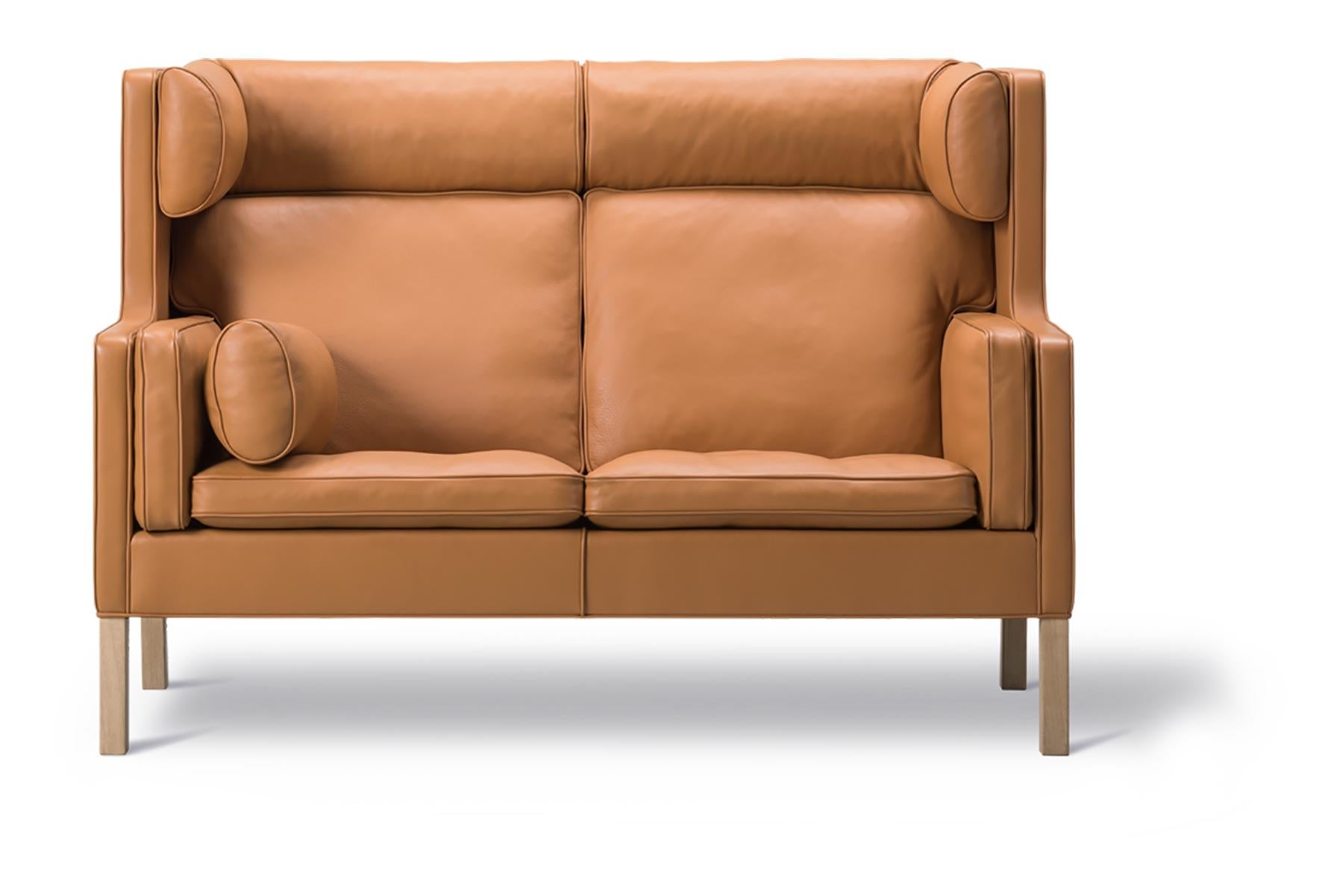 Das 1971 entworfene Coupé-Sofa hat eine hohe, umhüllende Rückenlehne mit Flügeln, die einen ruhigen Rückzugsort in größeren Räumen oder einen gemütlichen Platz vor einem Kamin bietet.