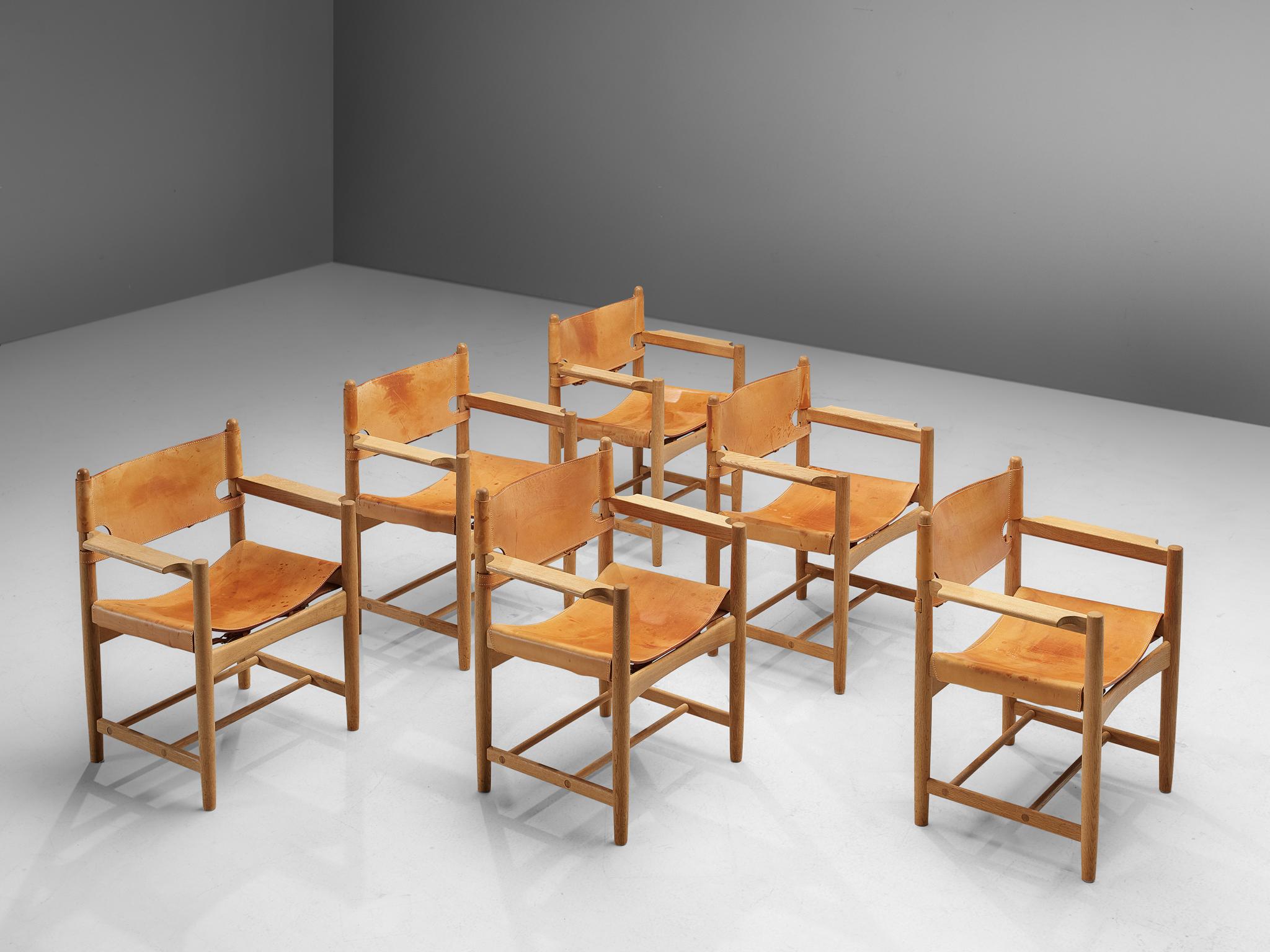 Børge Mogensen for Fredericia Stolefabrik, armchairs '238', in solid oak and leather, Denmark, 1964.

These chairs remind of the classical foldable 'director-chairs', yet this design by Danish designer Børge Mogensen (1914-1972) is from a more