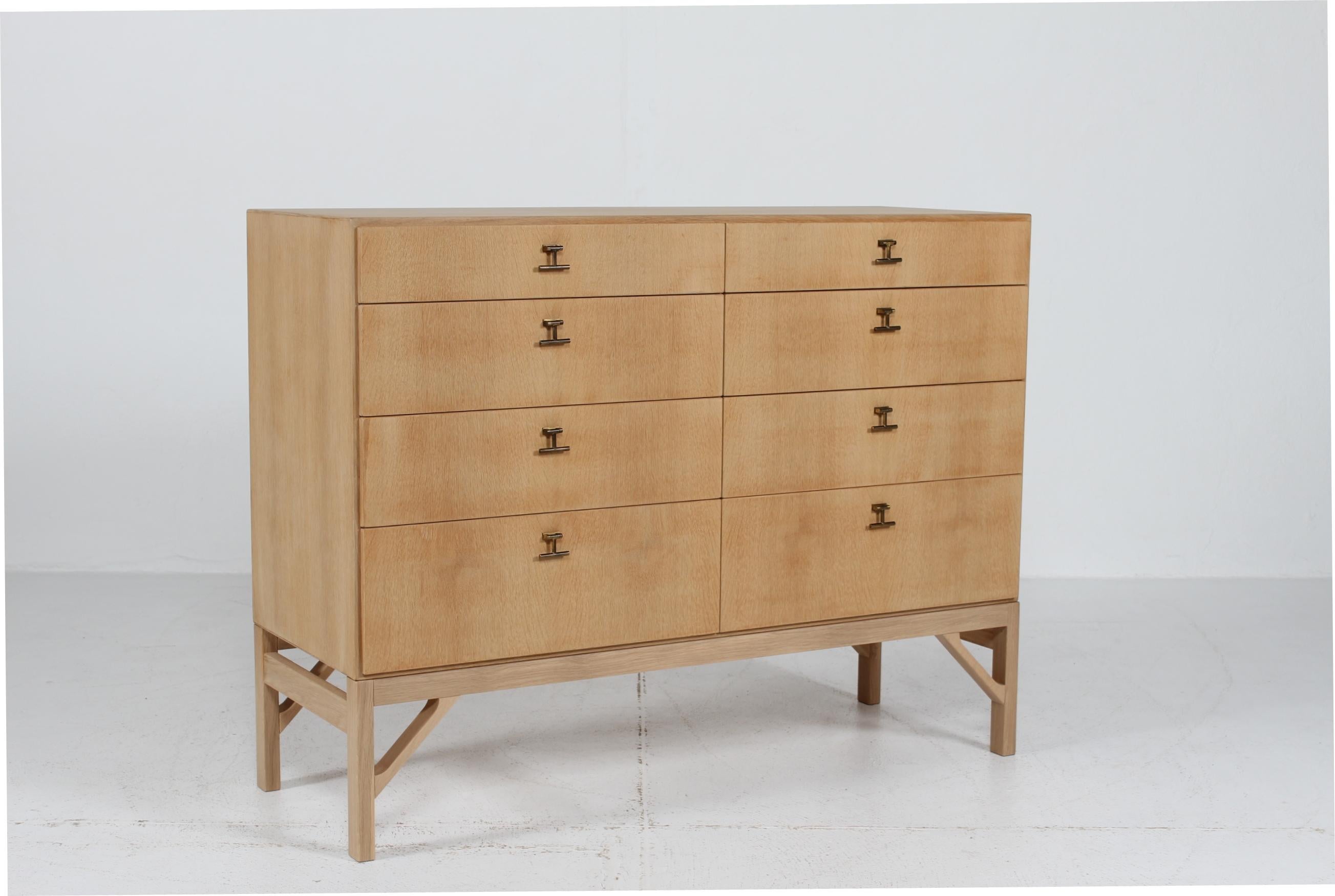 Danish architect Børge Mogensen (1914-1972) chest of drawers of solid and veneered oak with soap treatment. The classic storage furniture has 8 drawers mounted with brass drawer pulls. The China leg base of solid oak is of a newer date.

The chest