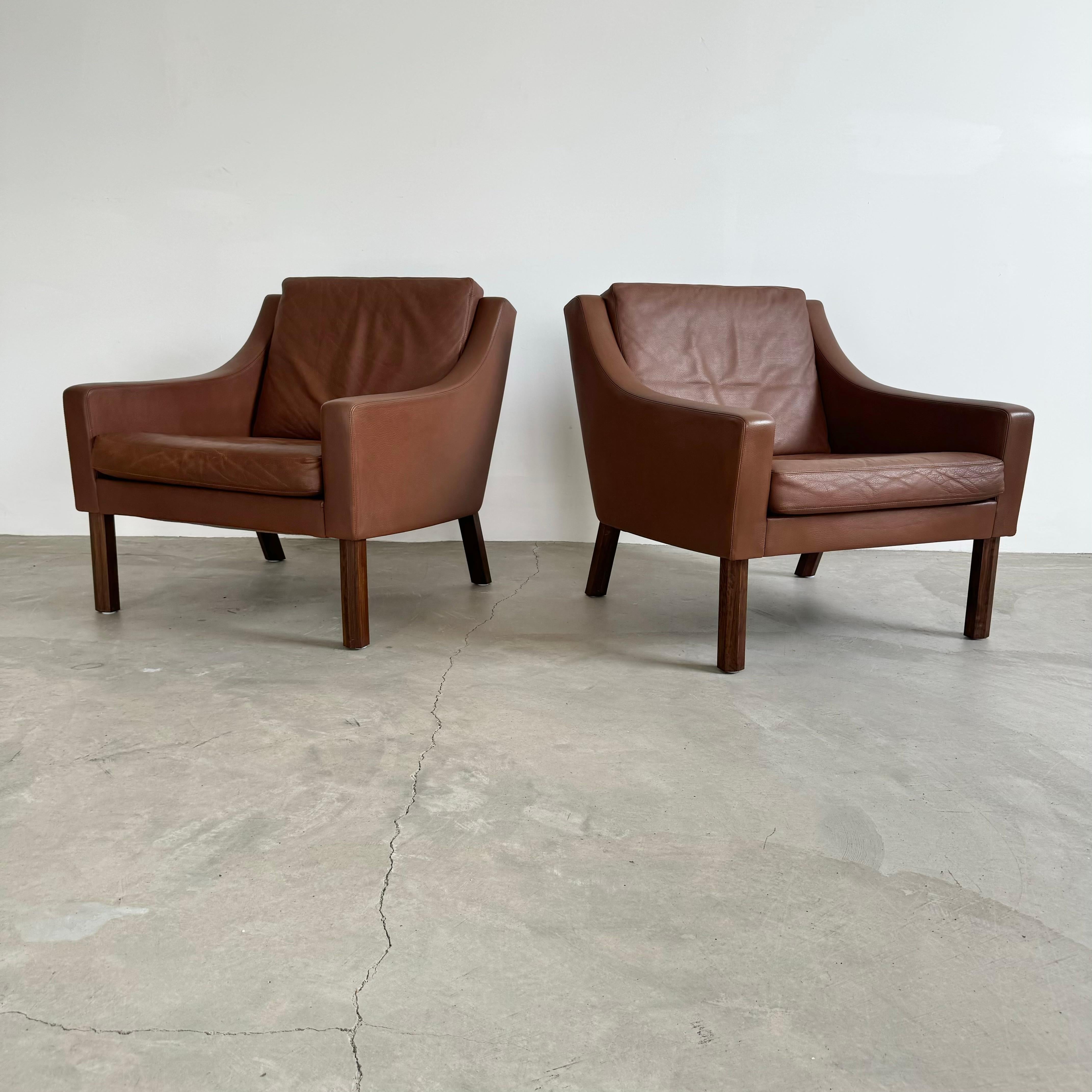 Pair of beautifully crafted, comfortable, and timeless lounge chairs from Denmark. Model #2207 designed by Børge Mogenson in 1963 and produced by Fredericia. 

These chairs have a rich, chocolate brown coloring that pairs immaculately with the teak