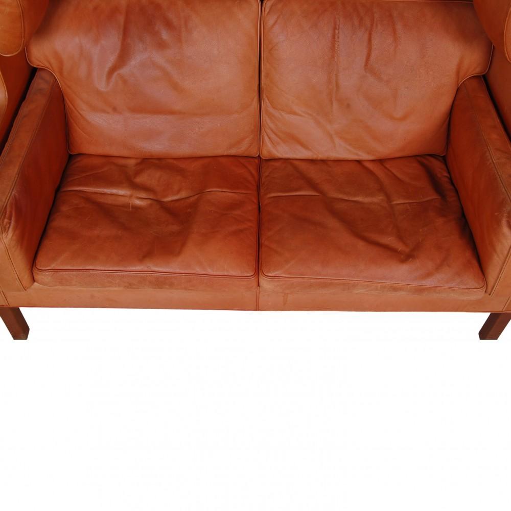 Børge Mogensen Coupé-Sofa 2192 in original patiniertem cognacfarbenem Leder aus den 80er- und 90er-Jahren. Das Sofa hat patiniertes Leder und Beine mit kleinen Chips, aber ohne Löcher im Leder oder Leinwand unter den Kissen.