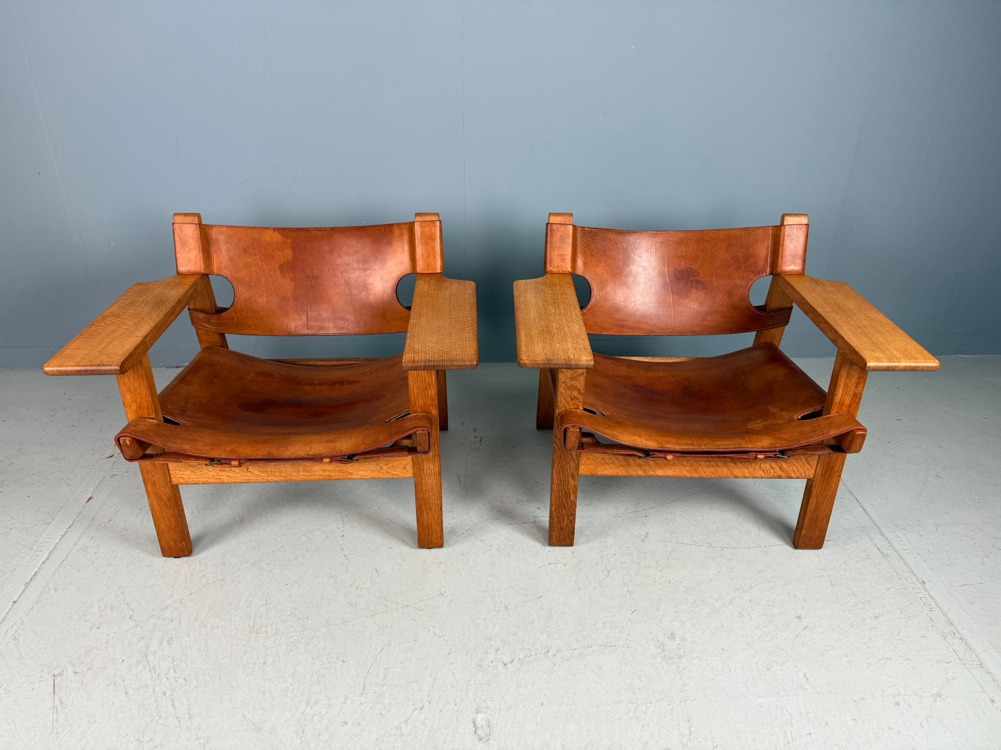Ein wunderschönes altes Paar der ikonischen spanischen Stühle von Børge Mogensen, Modell 226, hergestellt von Fredericia Stolefabrik, Dänemark, und mit dem originalen cognacfarbenen Sattelleder bezogen. Gekauft von den ersten Besitzern, die sie Ende