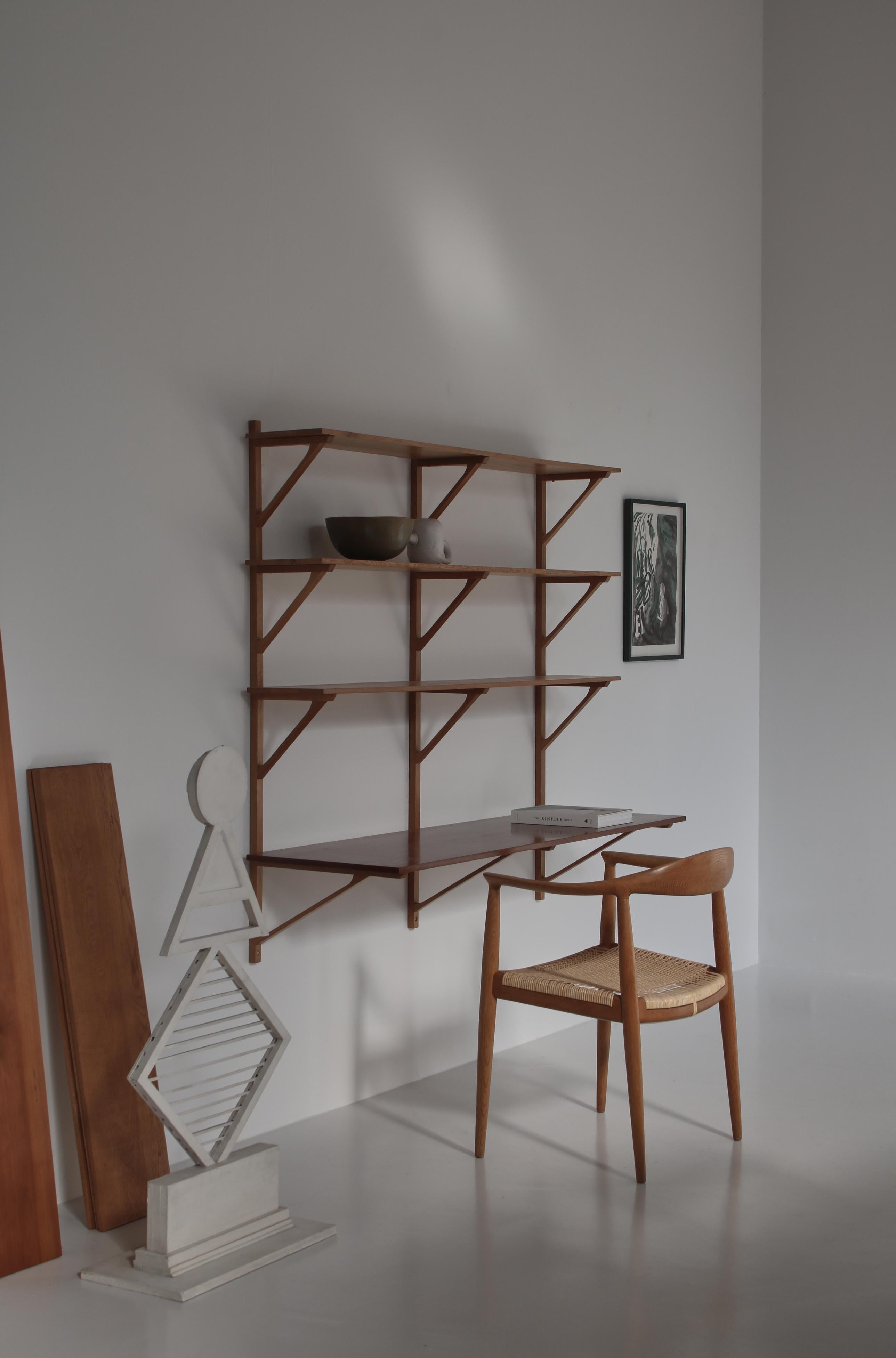 Important large wall shelving system in oak and teakwood designed by Børge Mogensen in 1956. This rare and early edition was made at cabinetmaker Erhard Rasmussen before the production was taken over by Fredericia Stolefabrik.

The three top