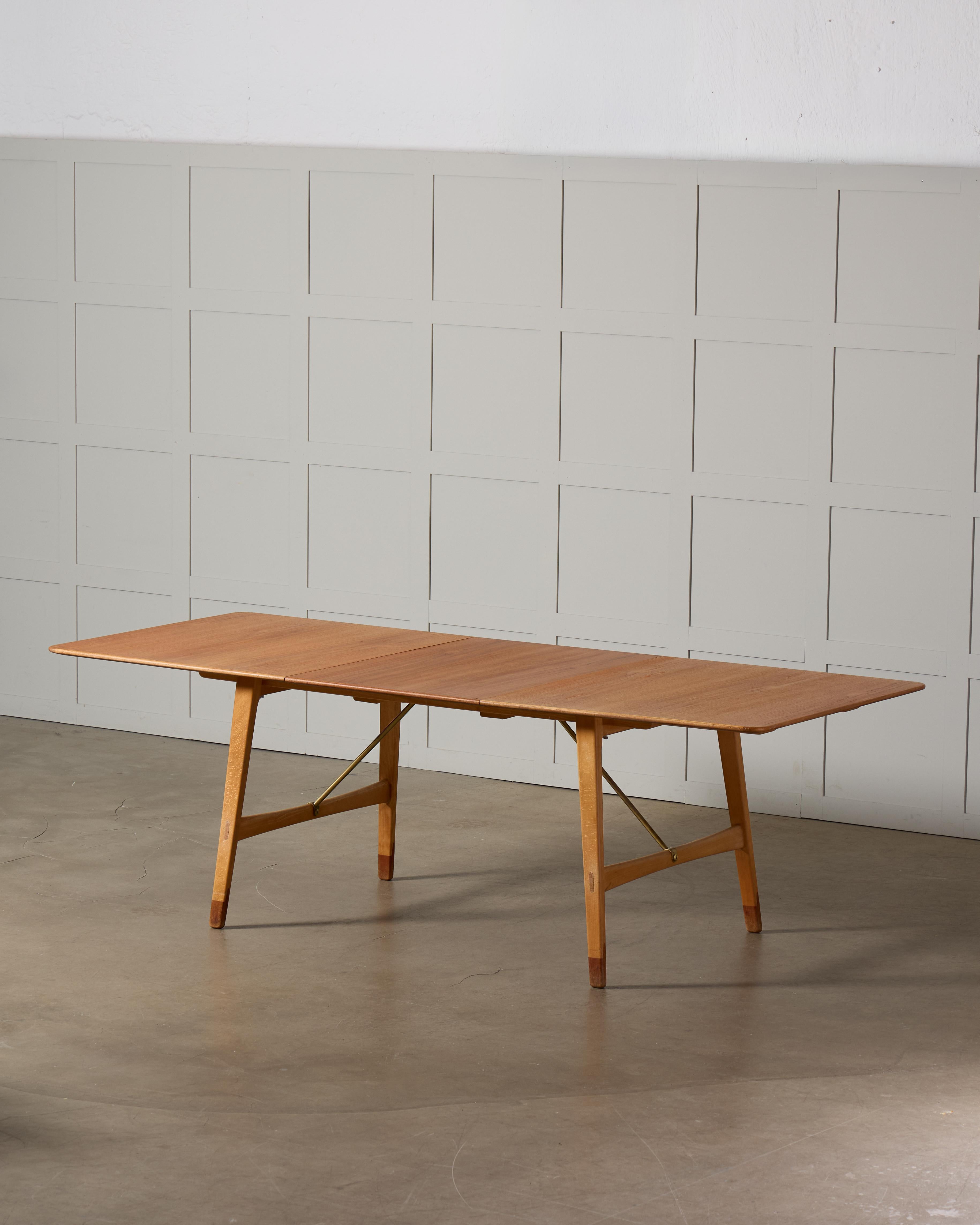 La table de salle à manger Model 753, conçue par le célèbre architecte danois Børge Mogensen, illustre l'éthique intemporelle du design scandinave. Fabriquée avec une combinaison de hêtre, de laiton et de teck, cette table reflète l'approche de