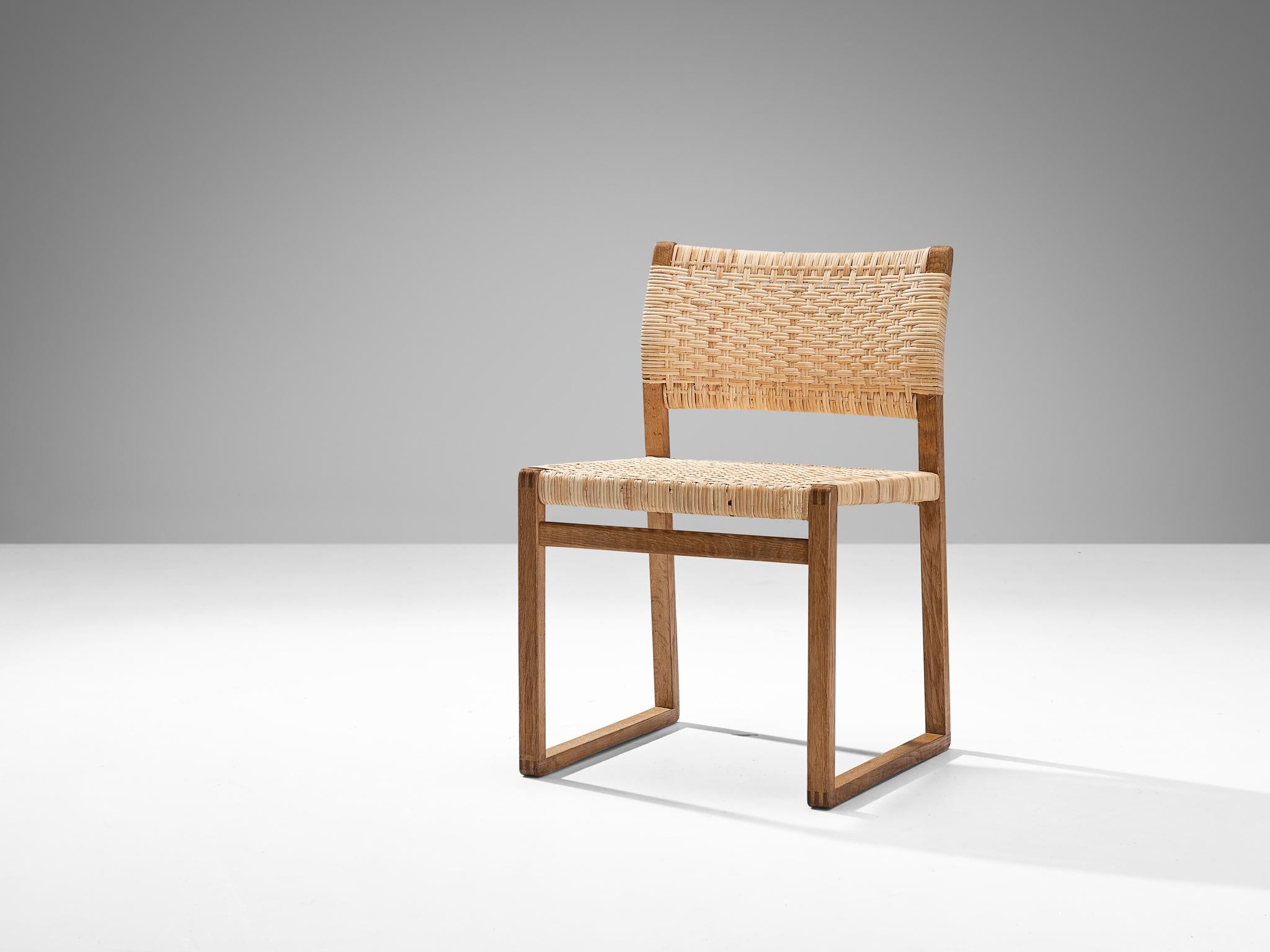 Børge Mogensen for Fredericia, dining chair, model ‘BM 61’, oak, cane wicker, Denmark, 1950s.

This naturalistic looking chair is characterized by a splendid design featuring simple shapes and authentic materials. The frame is composed of slender