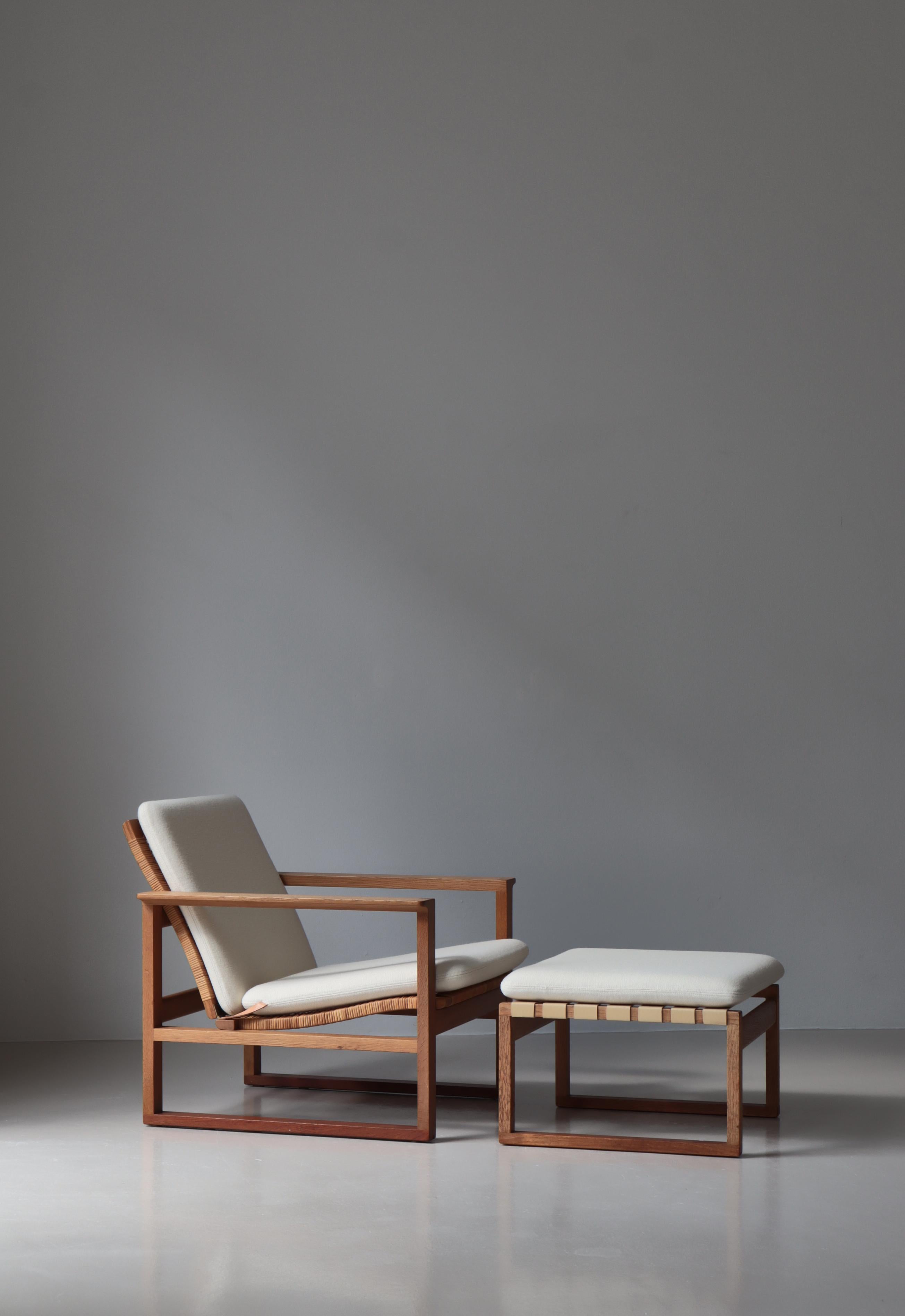 Early and important chair by Børge Mogensen. The model 246 features rattan cane on seat and back and solid teakwood sledge base attached to the oak construction with finger joints. The original footrest has been equipped with new Pirelli webbings in