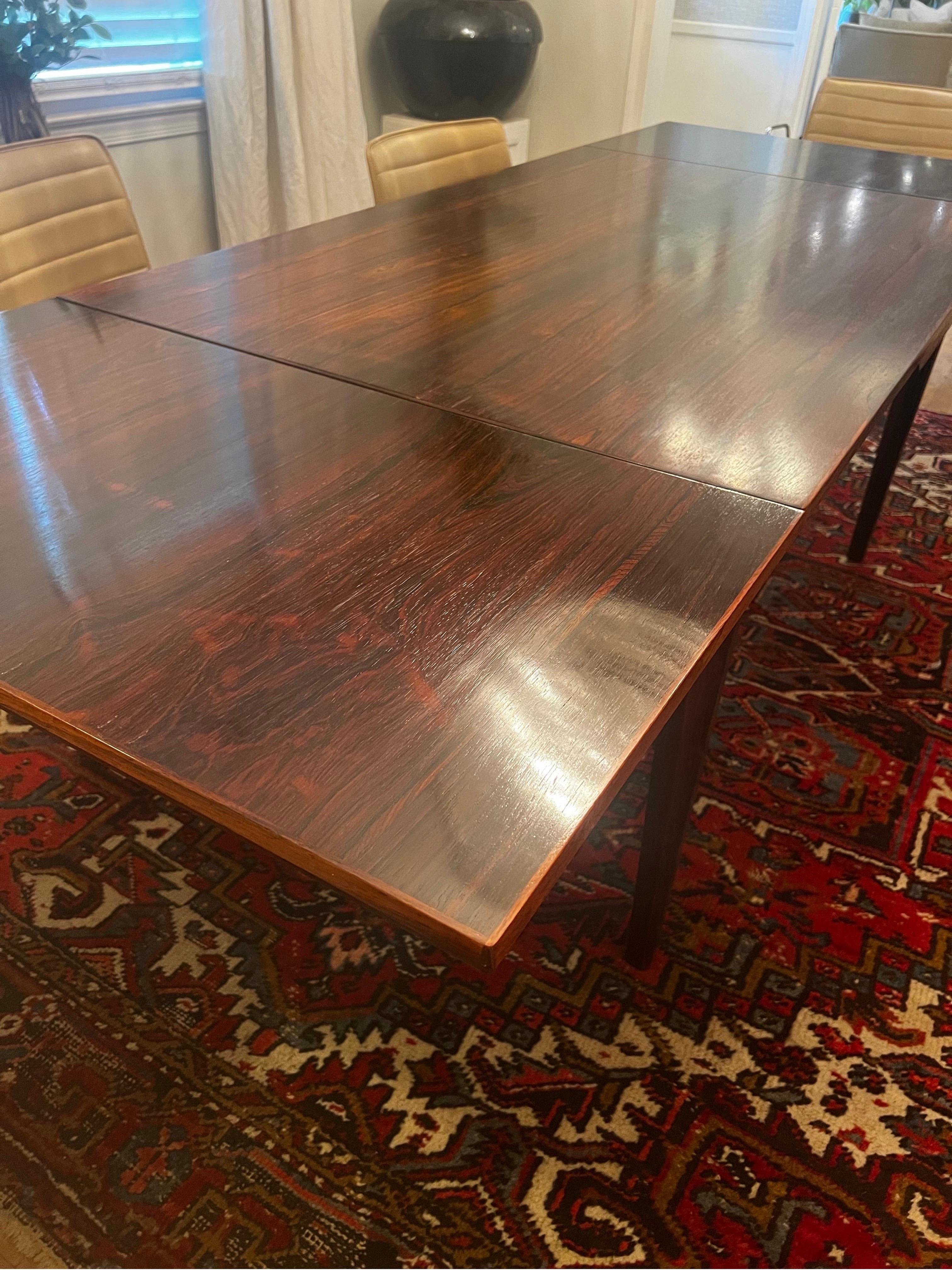 Mesa de comedor danesa Mid Century Modern/MCM con dos extensiones en cada extremo.   
Fabricado en Dinamarca.  
Acabado en palisandro oscuro.   Ver fotos.   

Se extiende desde 55 pulgadas hasta 74,5 pulgadas y 94 pulgadas.  

