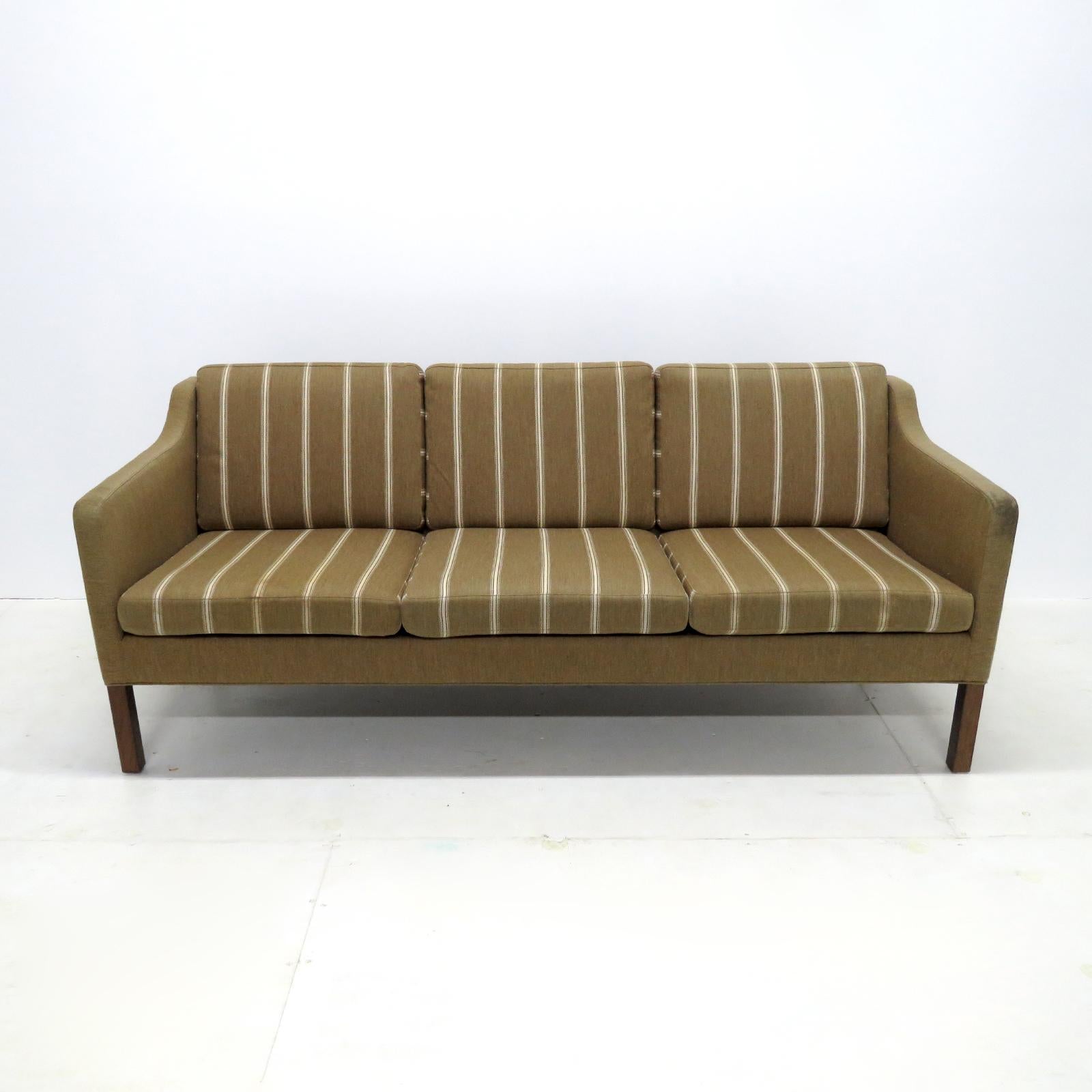 Stunning three-seat sofa model no. 2223, designed by Børge Mogensen in 1963 and produced by Frederica Stolefabrik, Denmark, in original mustard green wool with white/beige stripes on dark stained wood legs, marked.