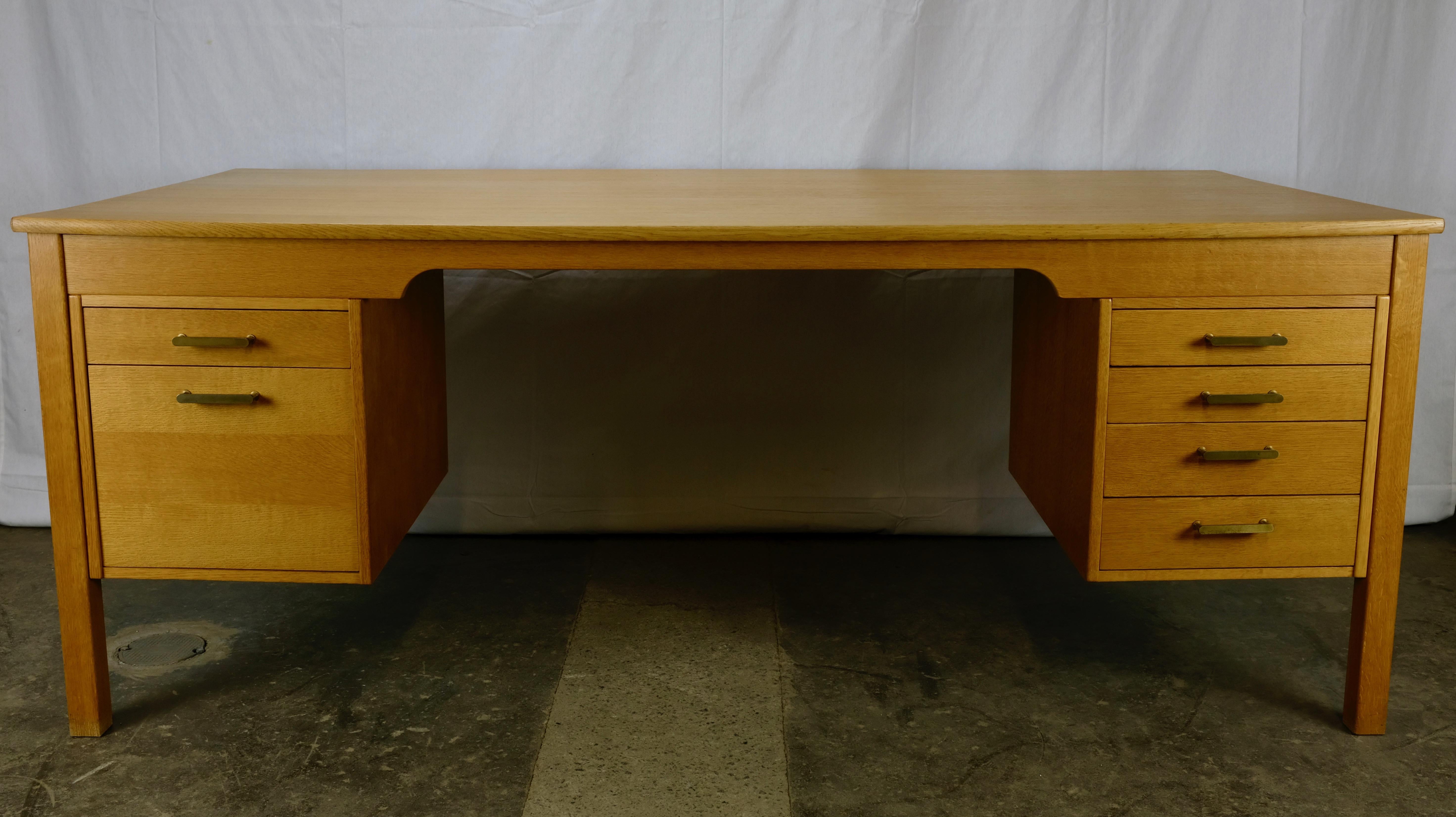 Large oak desk designed by Børge Mogensen and manufactured in Denmark by Søborg Møbelfabrik. Designed in 1970. 
The top is veneered in oak with solid oak edging while the legs, aprons and stretchers are all solid oak with several quartersawn