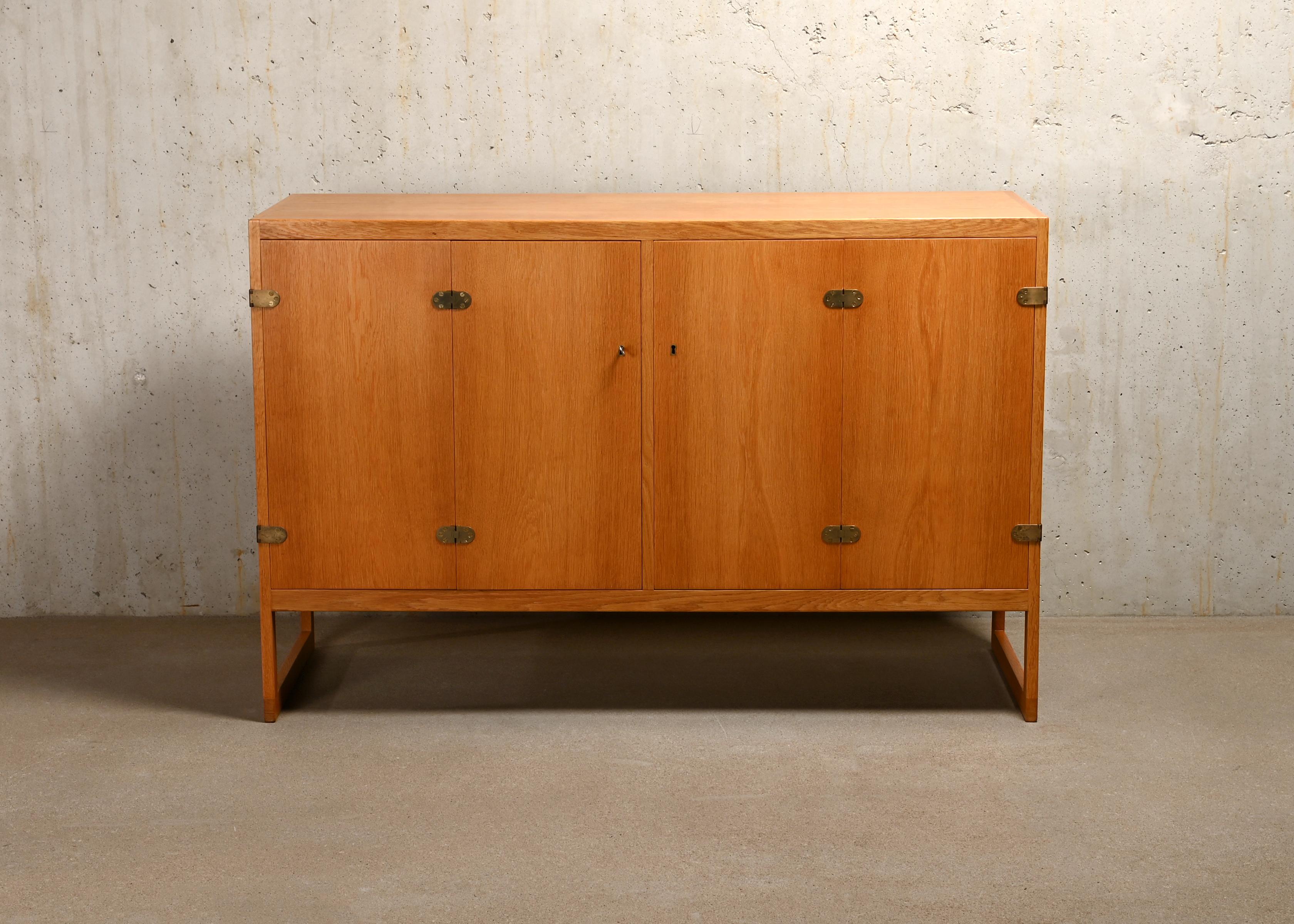 Beautiful sideboard model BM57 designed by Børge Mogensen in 1957 for P. Lauritsen & Søn. Oak wood with two bi-fold doors and brass hinges. One key is included. The interior layout with two shelves and 4 drawers can be easily changed manually. Very