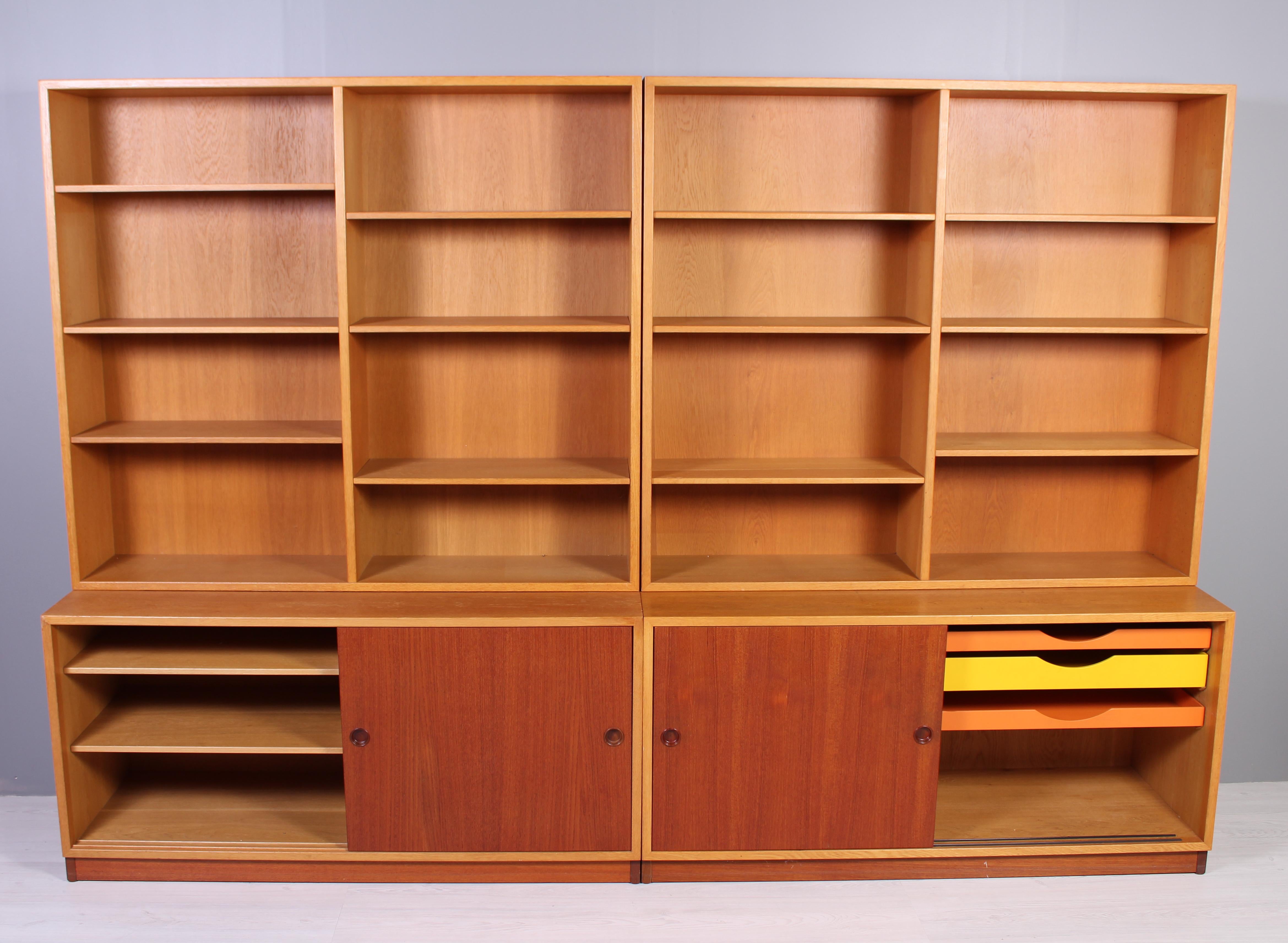 A pair of book cases by Danish designer Børge Mogensen produced by Swedish manufacturer Karl Andersson & Söner in the late 1950s. This is the early version of this design with the teak base and the colored drawers. These pieces was purchased in the