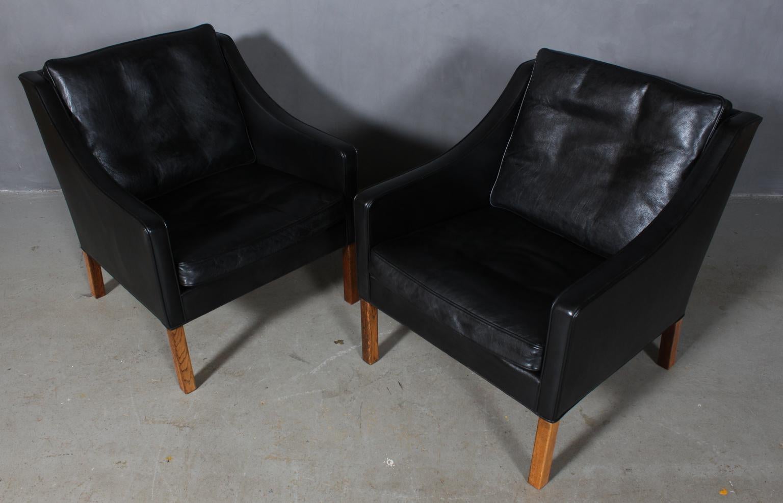 A pair of Børge Mogensen lounge chairs in original black leather upholstery. 

Legs in oak.

Model 2207, made by Fredericia furniture.