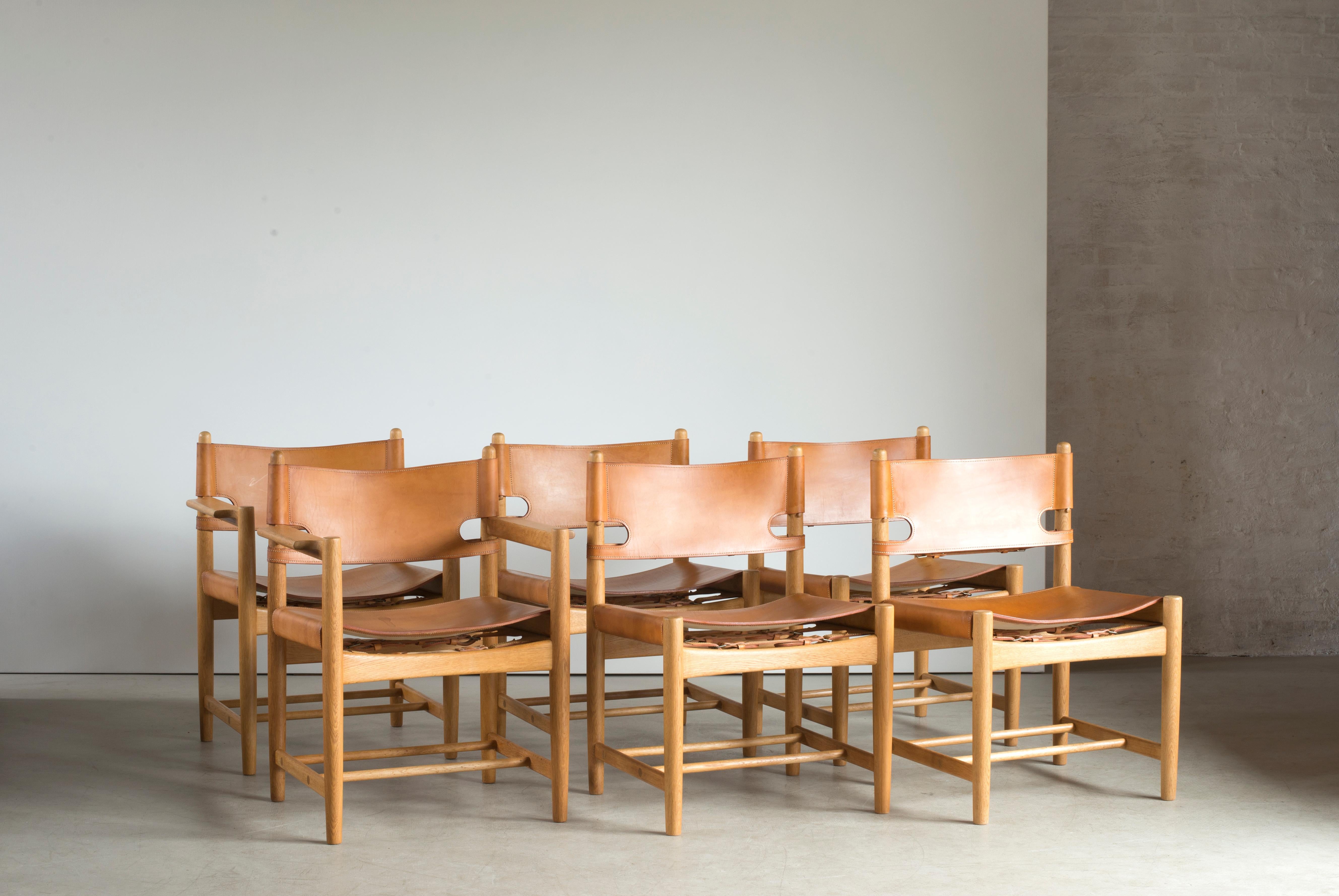 Børge Mogensen set of six dining chairs of oak and natural tanned leather. Two chairs with arms. Executed by Fredericia Furniture.