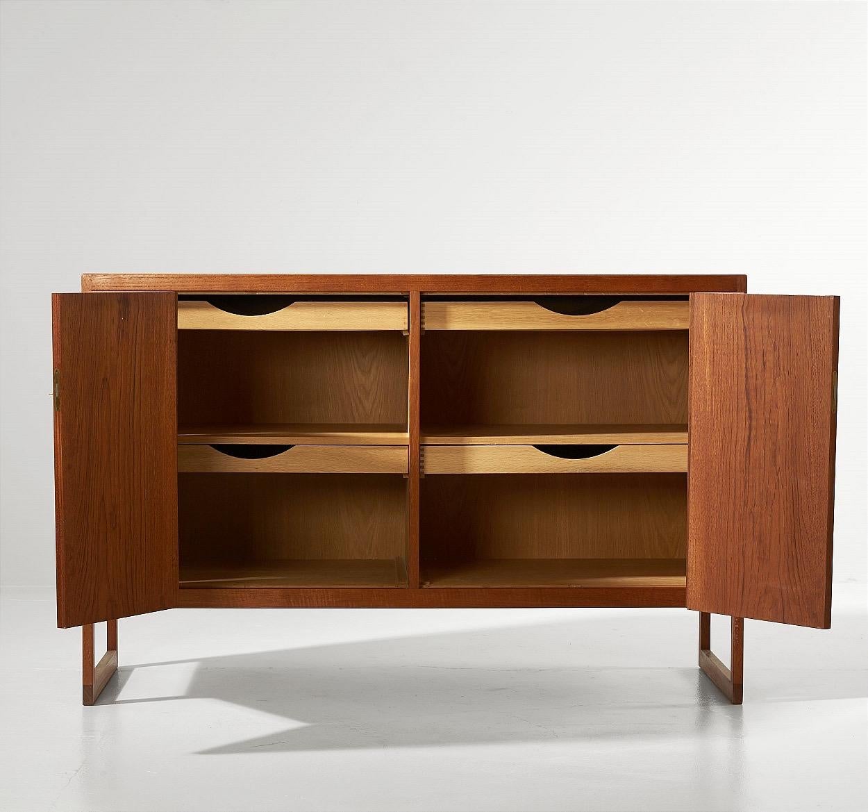 Teak sideboard designed by Børge Mogensen and produced by P. Lauritsen & Son

Sideboard with teak frame and oak interior drawers and adjustable shelves lined with felt

Folding front doors with keys included

Denmark, 1950s-1960s.