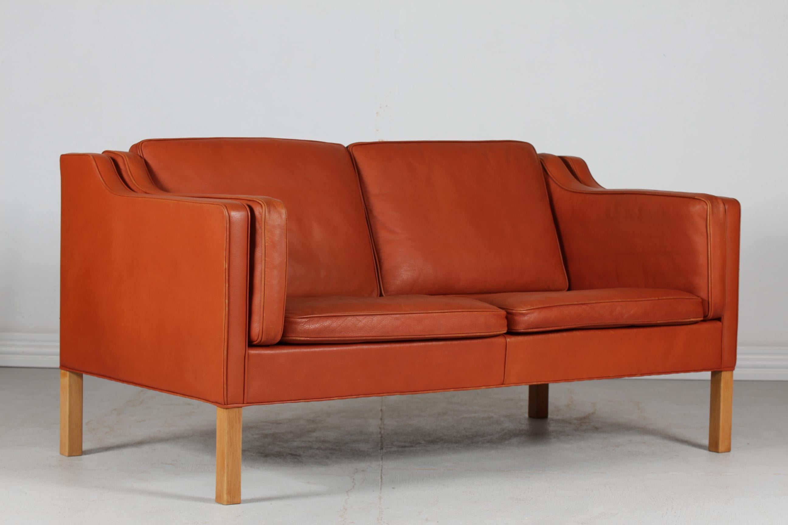 Børge Mogensen danish vintage 2 seater sofa model 2212.
It's upholstered with original cognac colored leather. The legs are made of oak. The cushions are filled inside with granules and natural feathers which give the sofa a very good seating