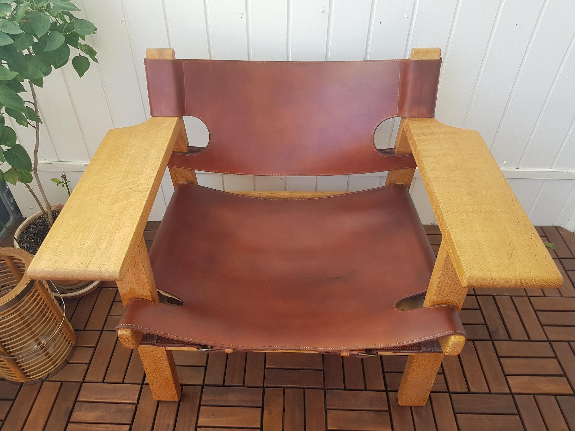 This oak and cognac leather Spanish chair was designed by Danish Børge Mogensen. The chair features wide armrests and leather details. Robust but still elegant. A true Scandinavian midcentury Classic. This particular item was produced in the 1960s.