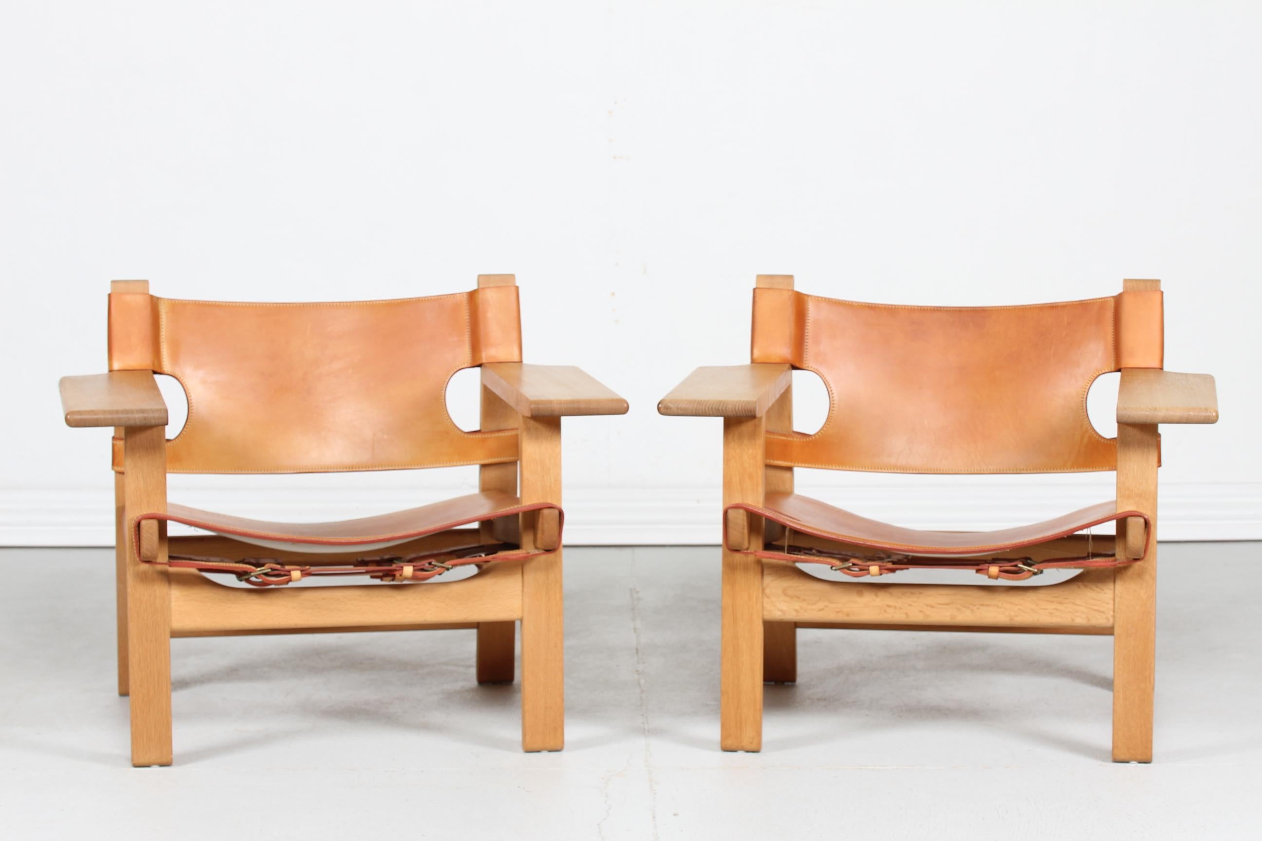 Pair of the Spanish chairs model BM 2226 by Danish designer Børge Mogensen.
They are made of genuine oak with good patina. The chairs have seats and backs of strong thick quality leather in cognac color with beautiful patina.

Paper label under