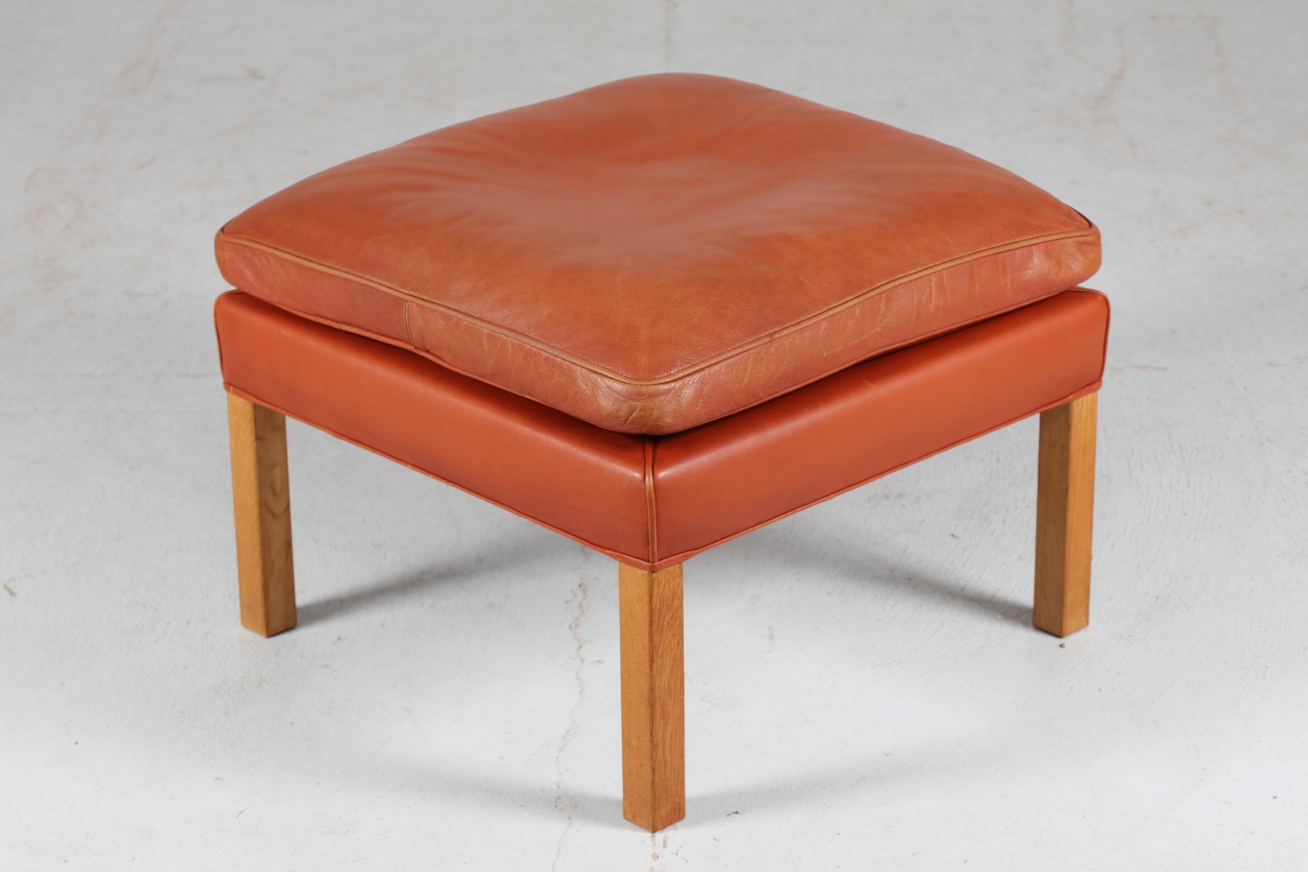 Danish vintage Børge Mogensen stool model 2202.
It's upholstered with the original cognac colored leather. The legs are made of oak. The cushion is filled inside with granules and natural feathers which give the stool a very good seating