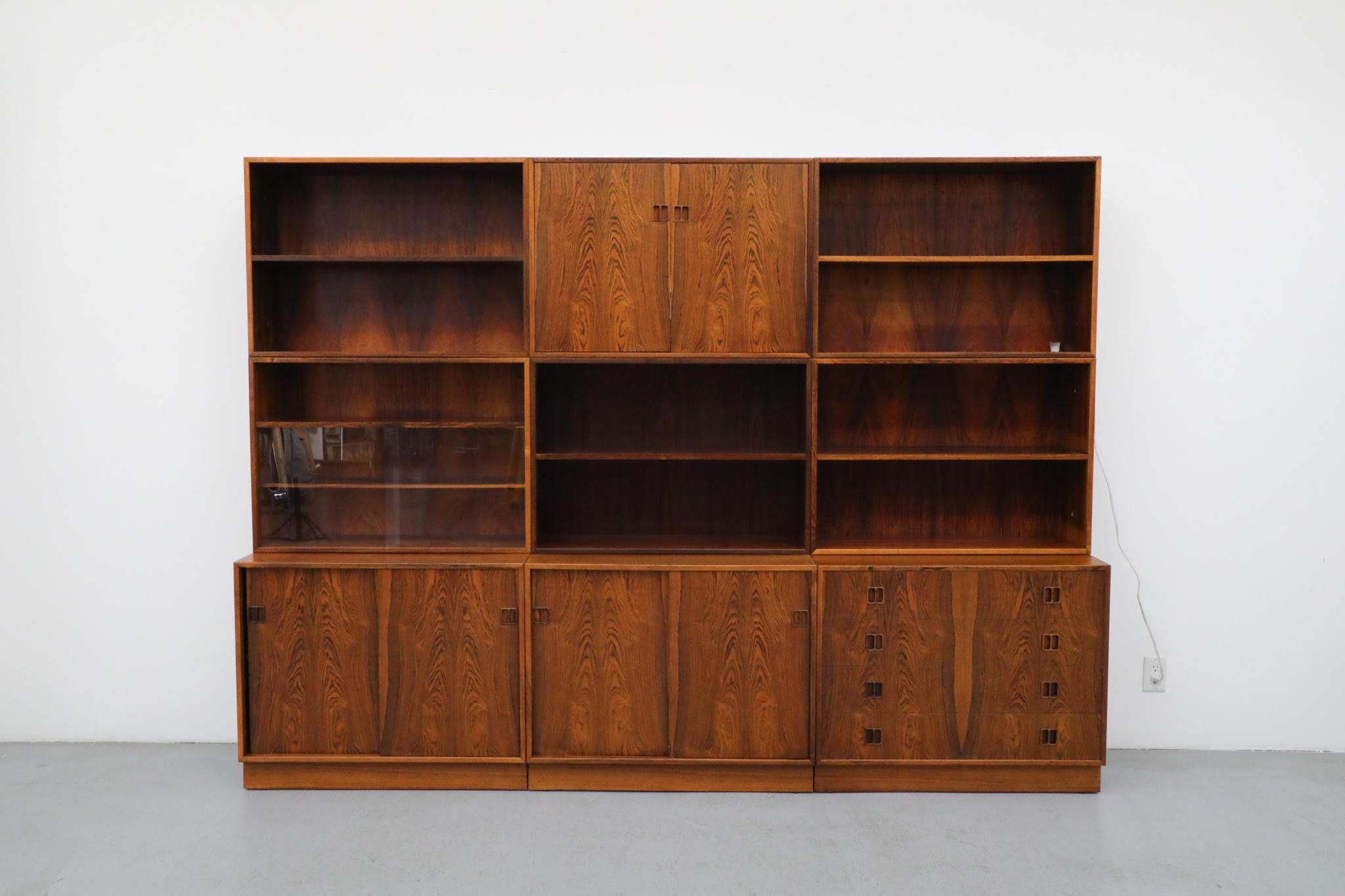 Elegante e funzionale pensile modulare danese del Mid-Century, ispirato all'etica raffinata e pratica di Børge Mogensen. Realizzato in legno di palissandro con una ricca venatura e abbinato al libro, questo sistema a tre colonne esemplifica