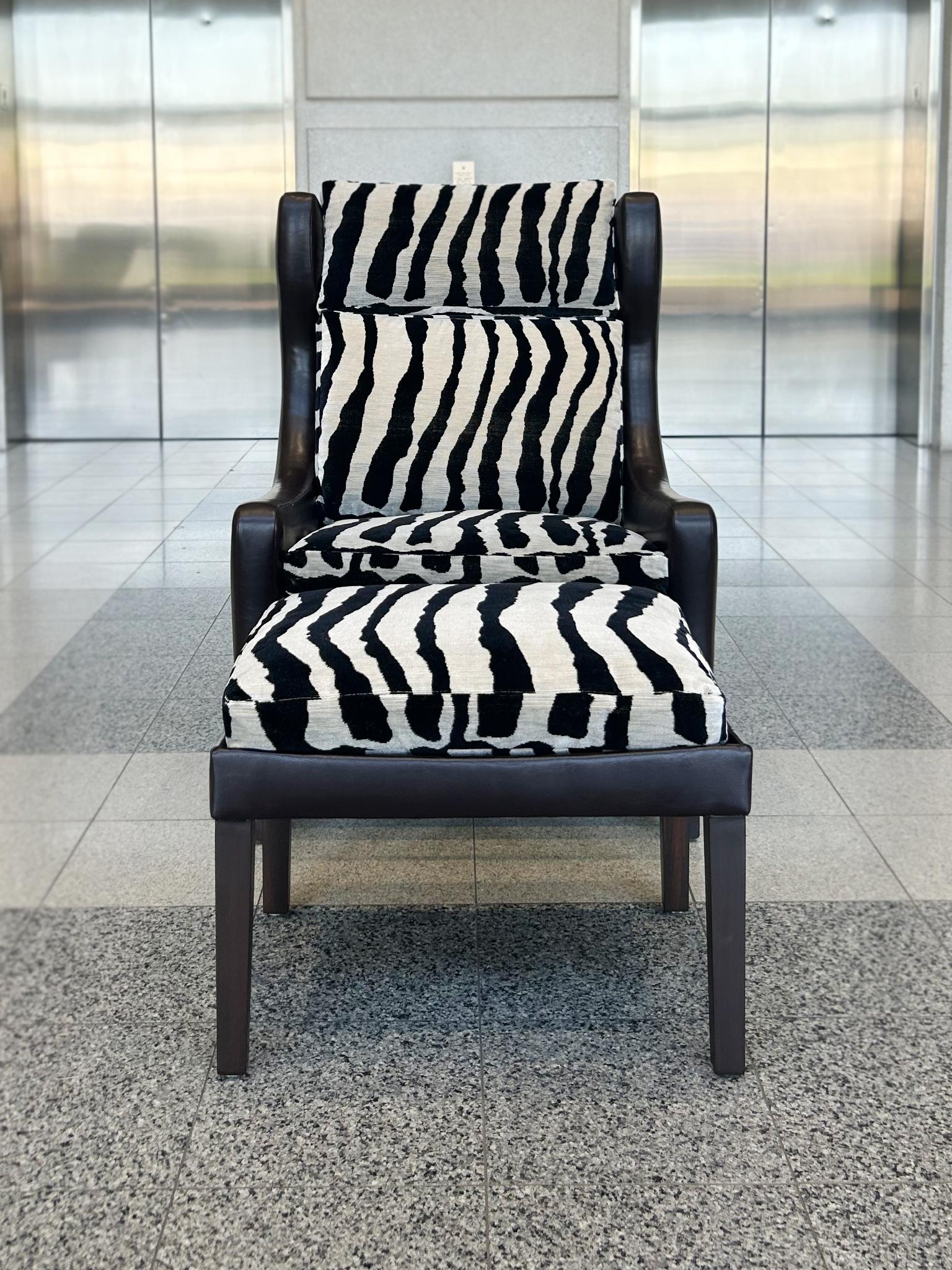 Designed in the style of Børge Mogensen, this Danish Modern set was originally made in the 1960s and includes a wingback armchair and an ottoman. Both pieces have been entirely refashioned with dark brown leather upholstery. Their new removable