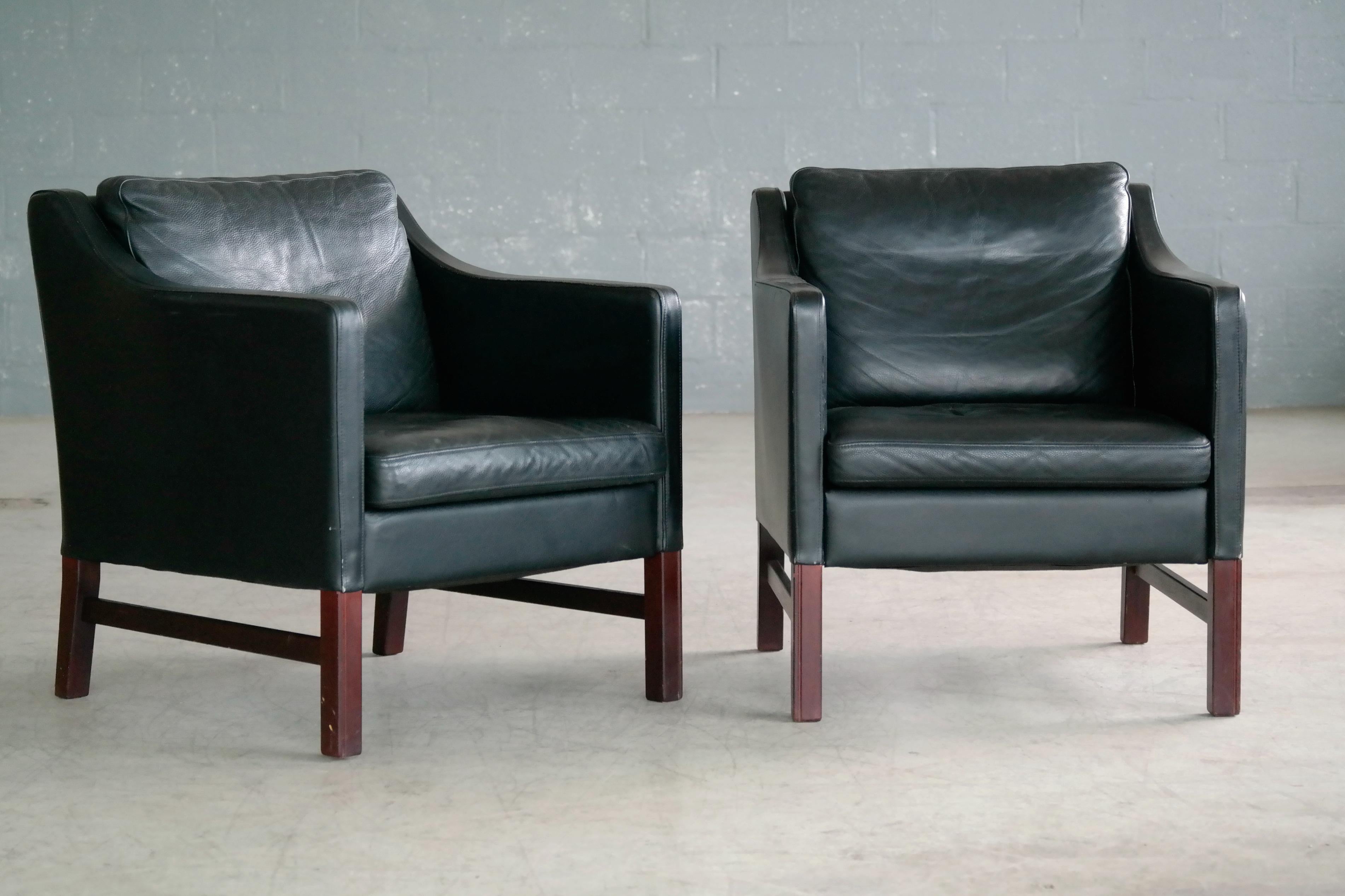 Very elegant pair of lounge chairs in the style of Borge Mogensen designed by Erik Marquardsen and Takashi Okamura as model Admiral and produced by Svend Skipper in the 1970s. The chairs have fluted legs in stained beech and are covered in a