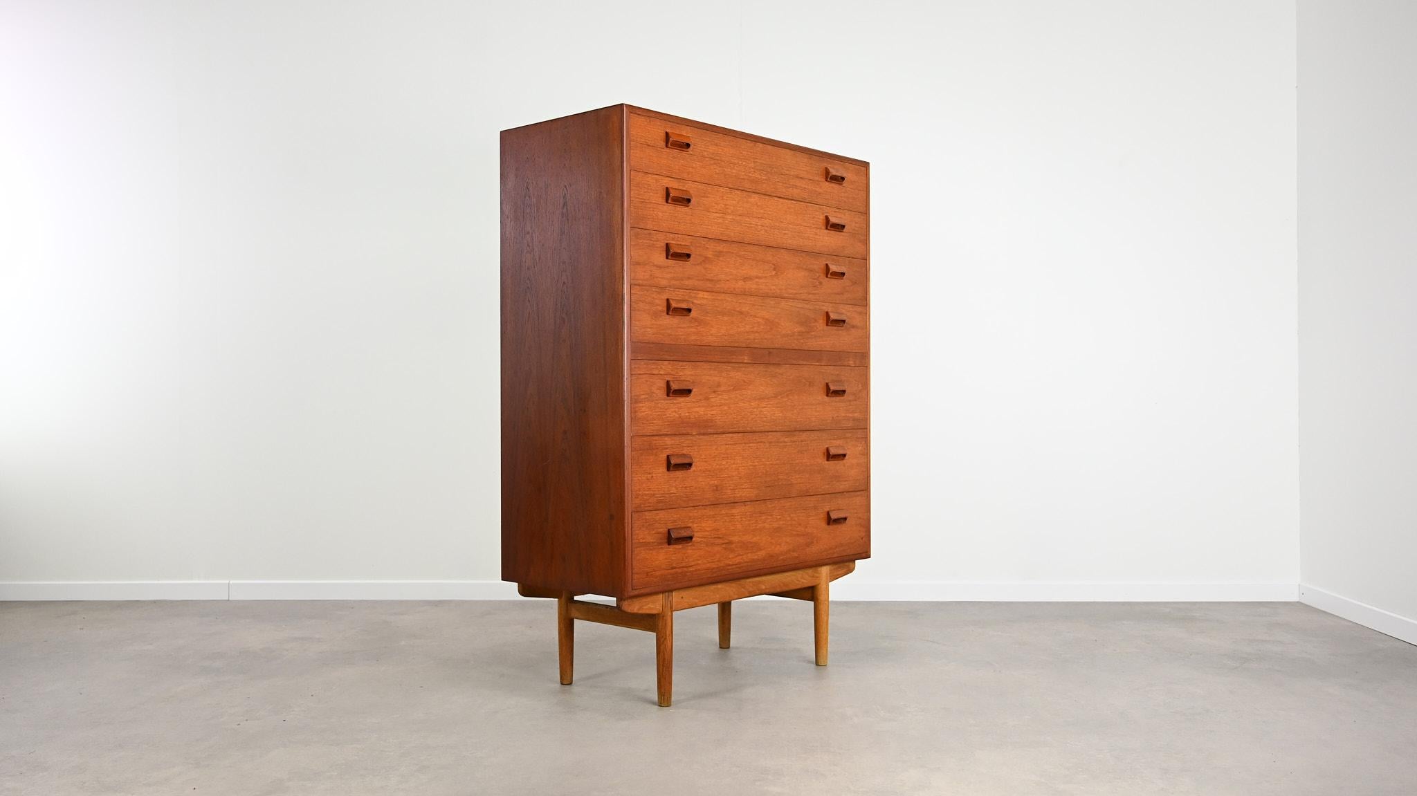 Designed by Børge Mogensen and manufactured by Søborg Møbelfabrik in the 1960s in Denmark, this chest of drawers is made of teak and teak veneer resting on an oak base. It opens by seven drawers on the front and surprises with its oversized