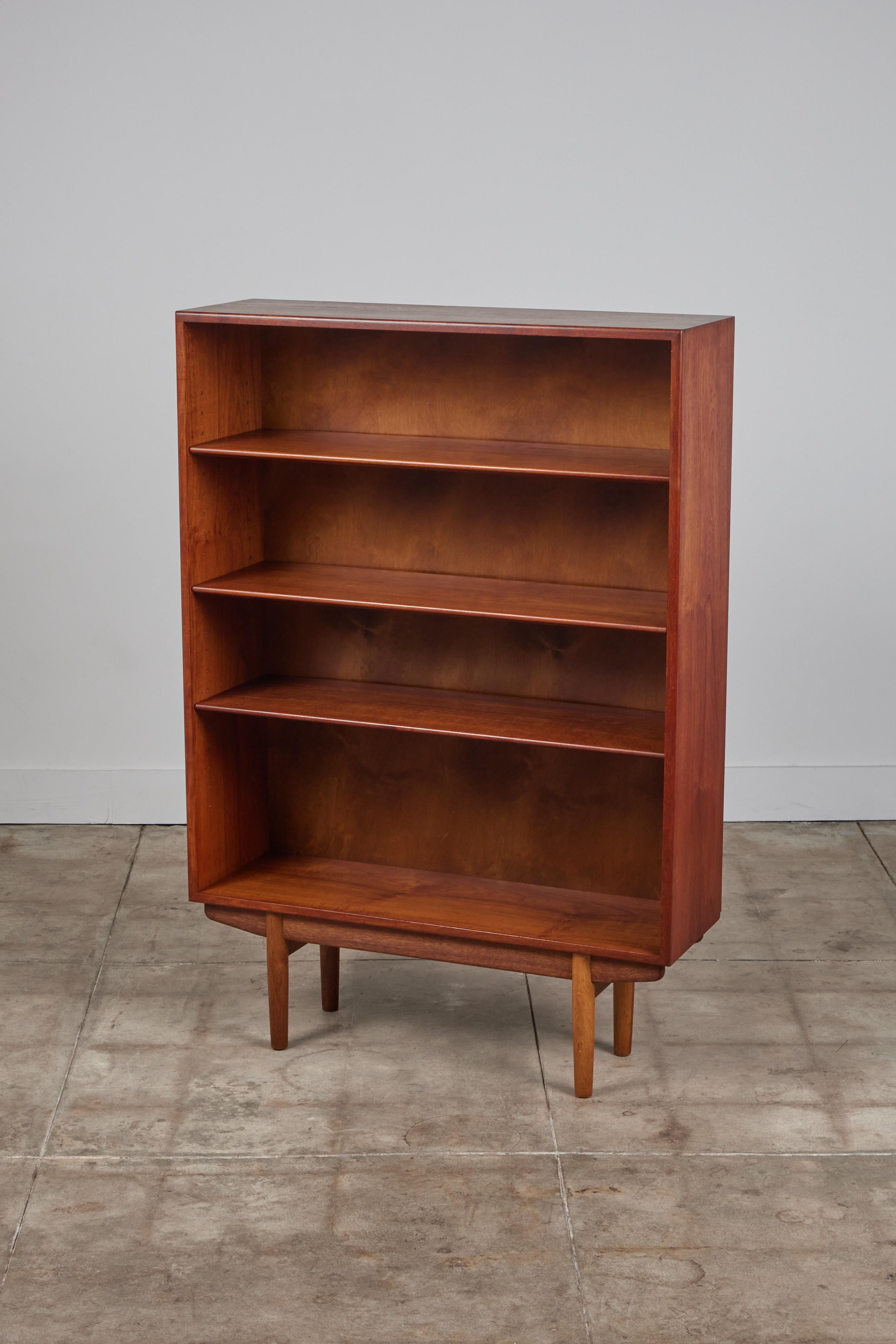 Børge Mogensen teak bookcase from Aalborg, Denmark, circa 1950s. The cabinet features a slender teak exterior frame and tapered turned legs. It has three adjustable shelves.

Dimensions
39.25