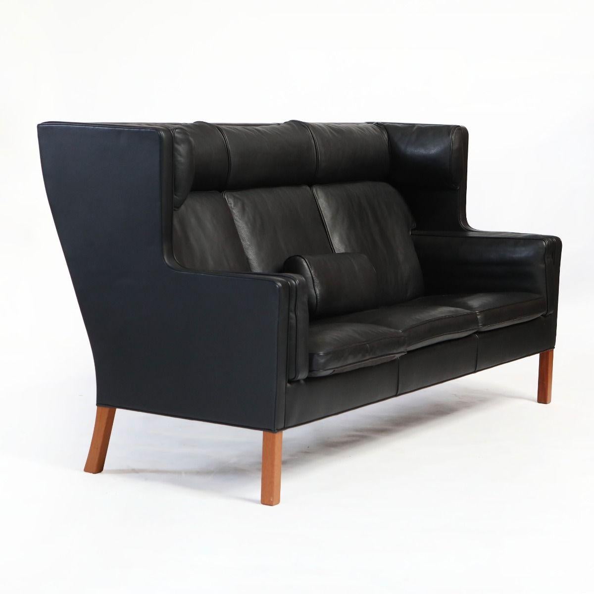Børge Mogensen, 1914–1972

3-seater coupe sofa, model 2193, in outstanding quality.
Originally designed in 1971, manufactured by Fredericia Furniture in the 1990s.
Upholstered in black leather with solid mahogany legs.
Known for its high back and