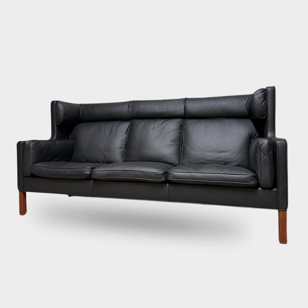Børge Mogensen two-person coupé sofa. Newly upholstered with black leather cover. Legs in Teak

Model 2192, manufactured by Fredericia Furniture.
Architect: Børge Mogensen (designer), Fredericia (producer)
Dimensions: Height: 106 cm, Width: 215 cm,