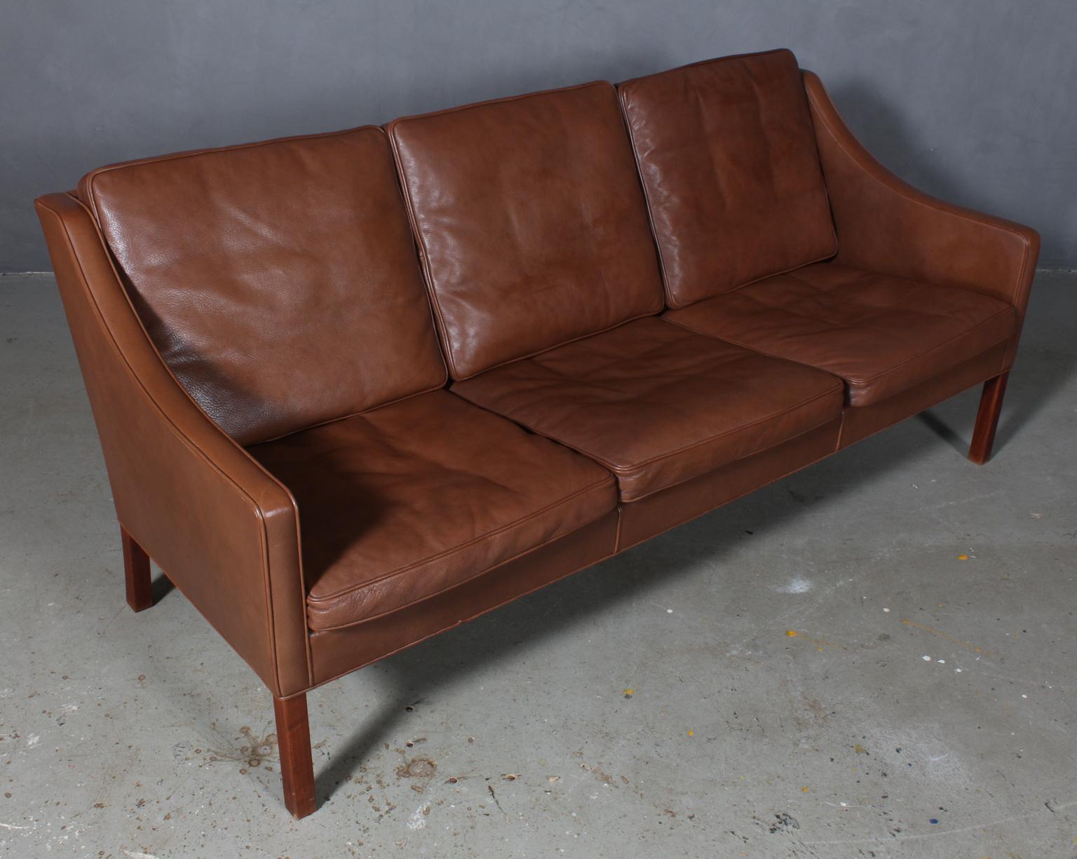 Børge Mogensen three-seat sofa original upholstered in brown leather.

Legs of teak.

Model 2209, made by Fredericia Furniture.
