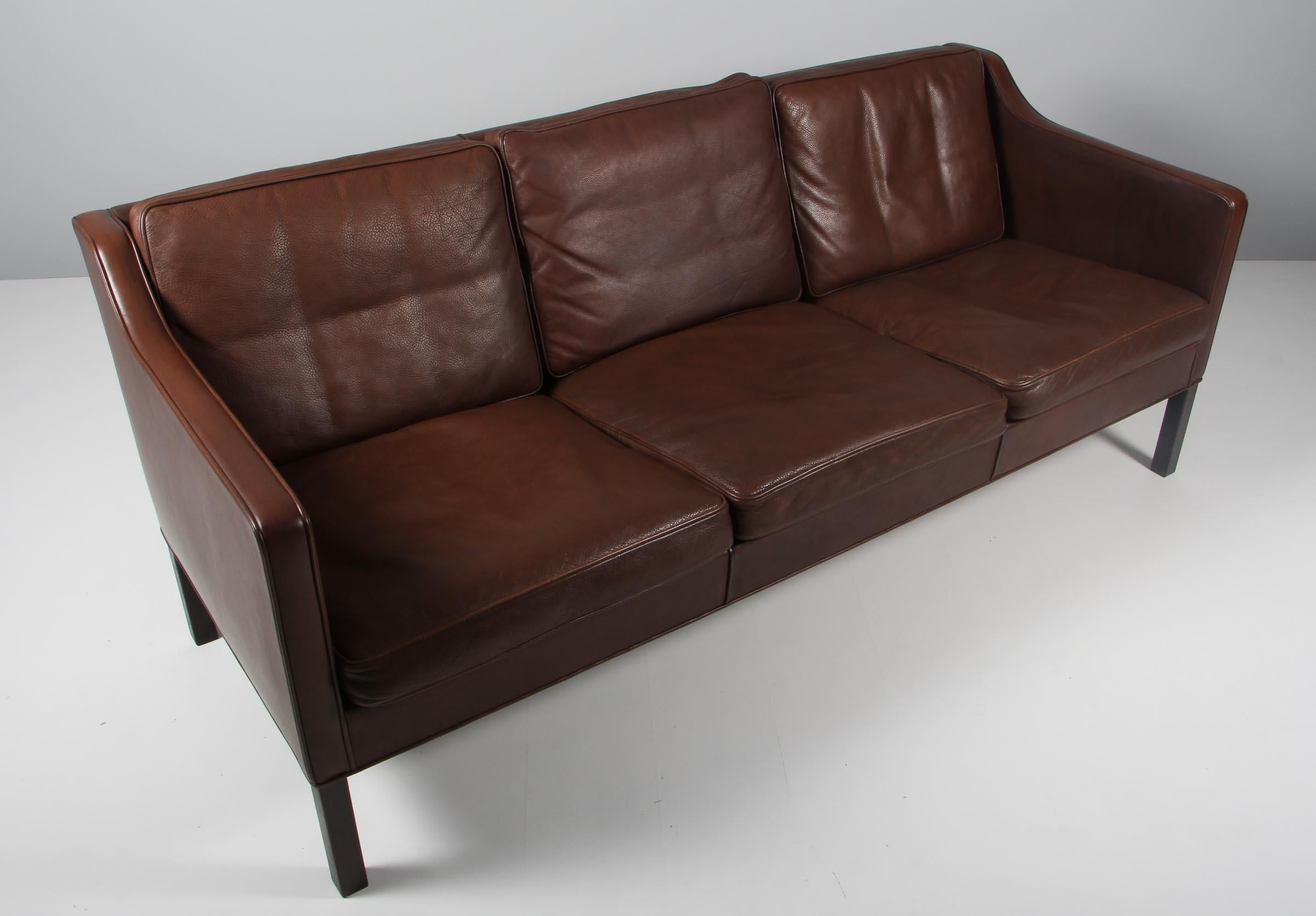 Børge Mogensen three-seat sofa original upholstered in brown leather.

Legs of smoked oak.

Model 2523, made by Fredericia Furniture.