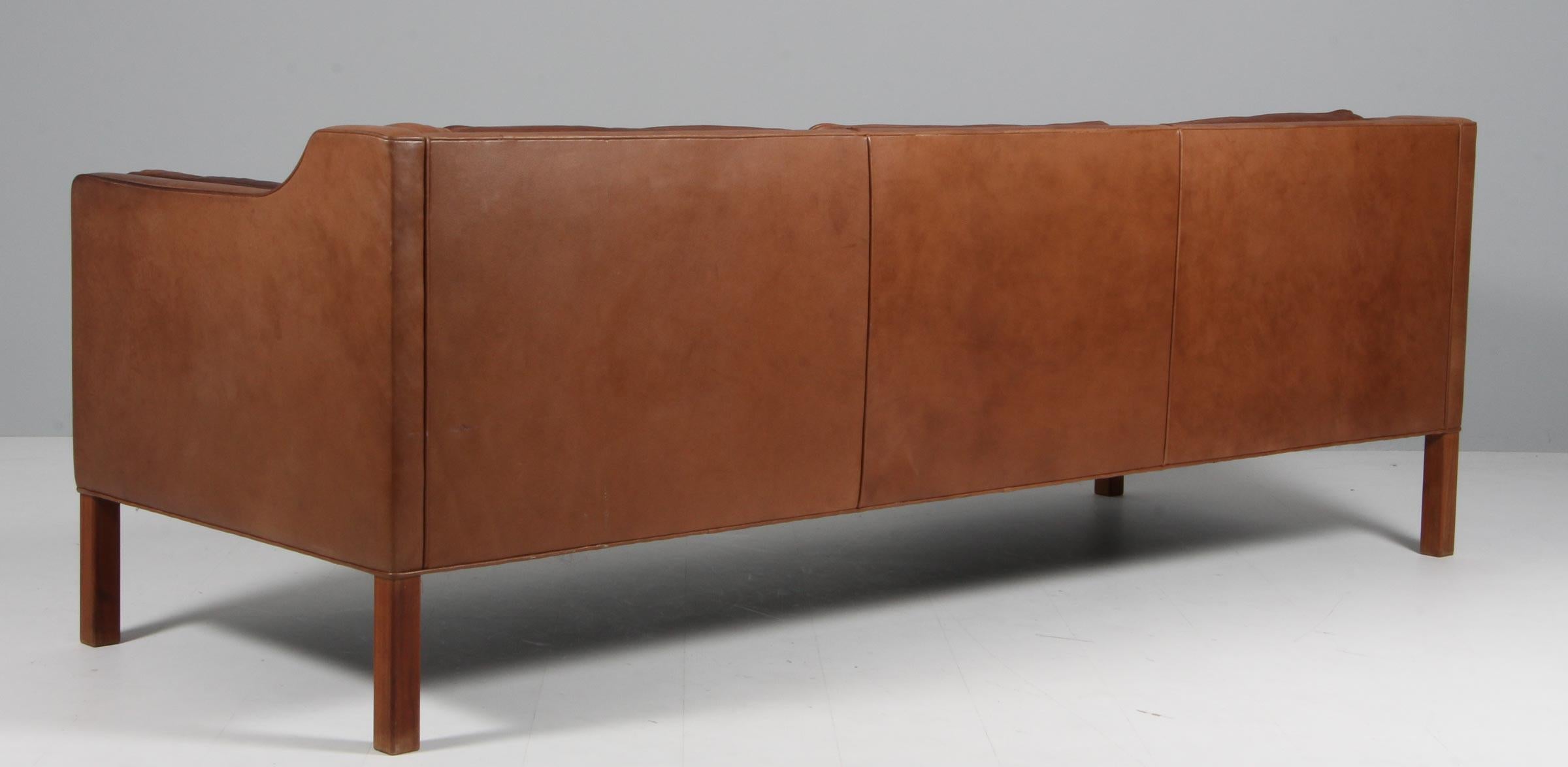 Børge Mogensen three-seat sofa with original patinated brown leather upholstery.

Legs of mahogany.

Model 2213, made by Fredericia Furniture.