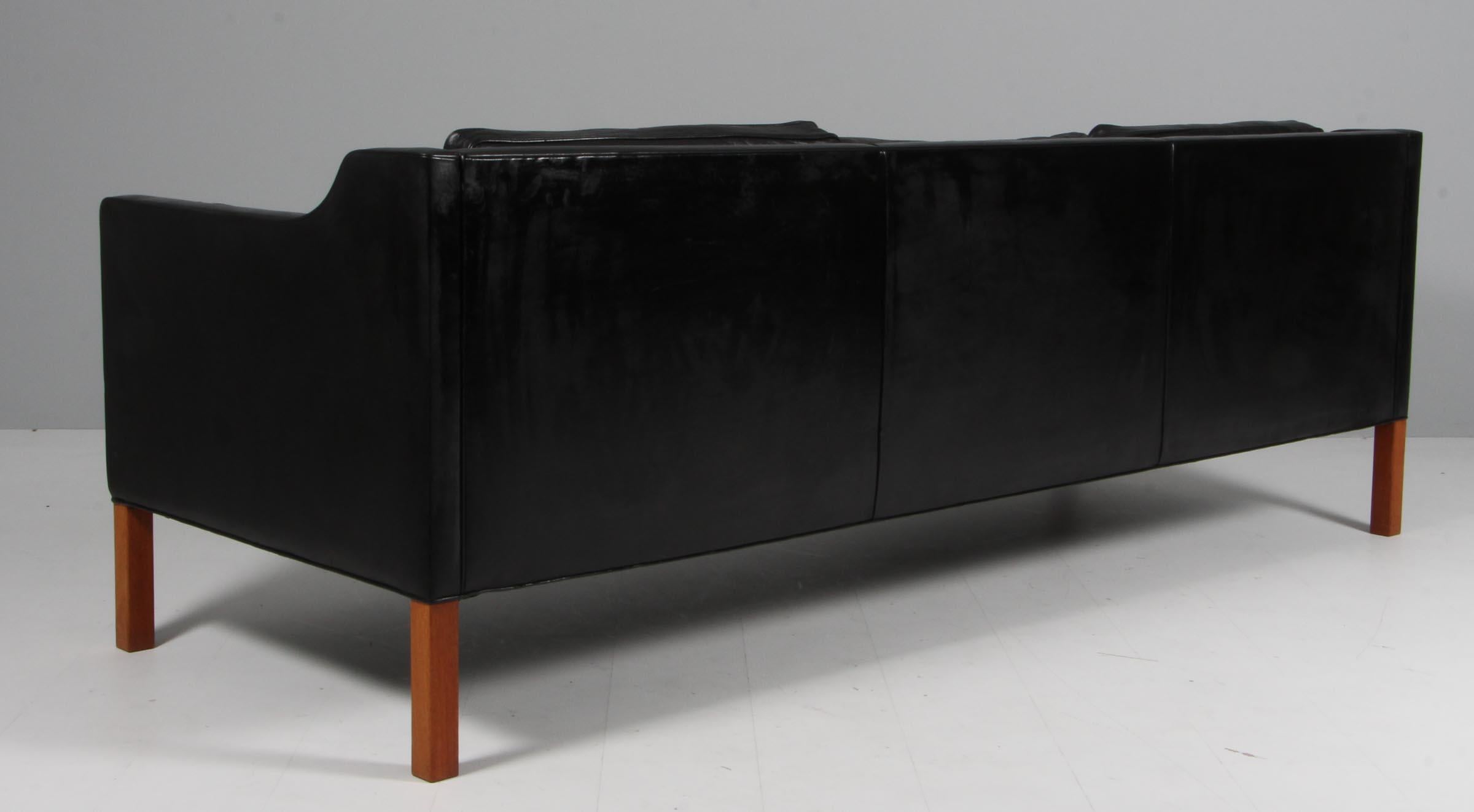 Børge Mogensen three-seat sofa with original patinated black leather upholstery.

Legs of teak.

Model 2213, made by Fredericia Furniture.