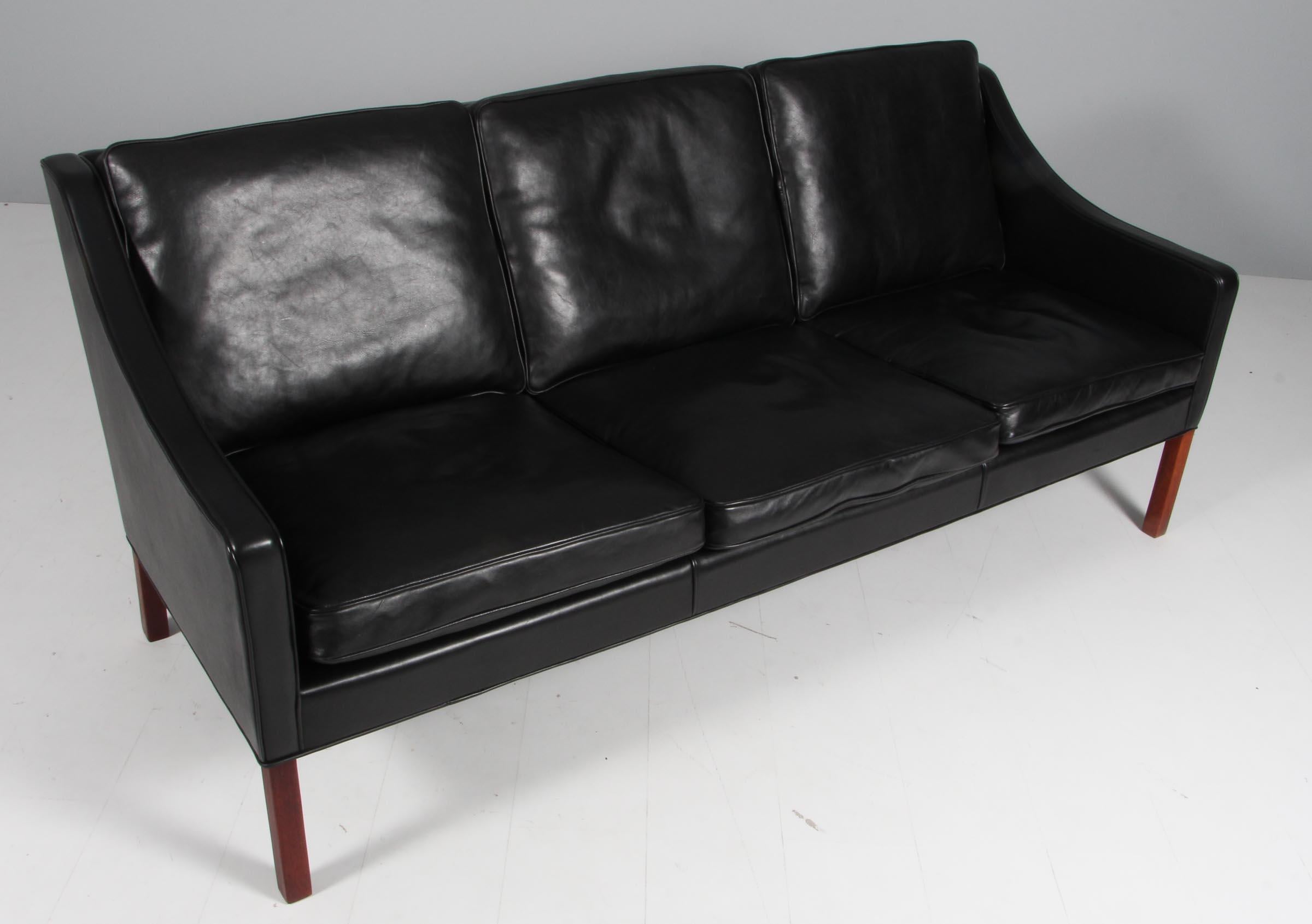 Børge Mogensen three-seat sofa original upholstered in black leather.

Legs of mahogany.

Model 2209, made by Fredericia Furniture.
