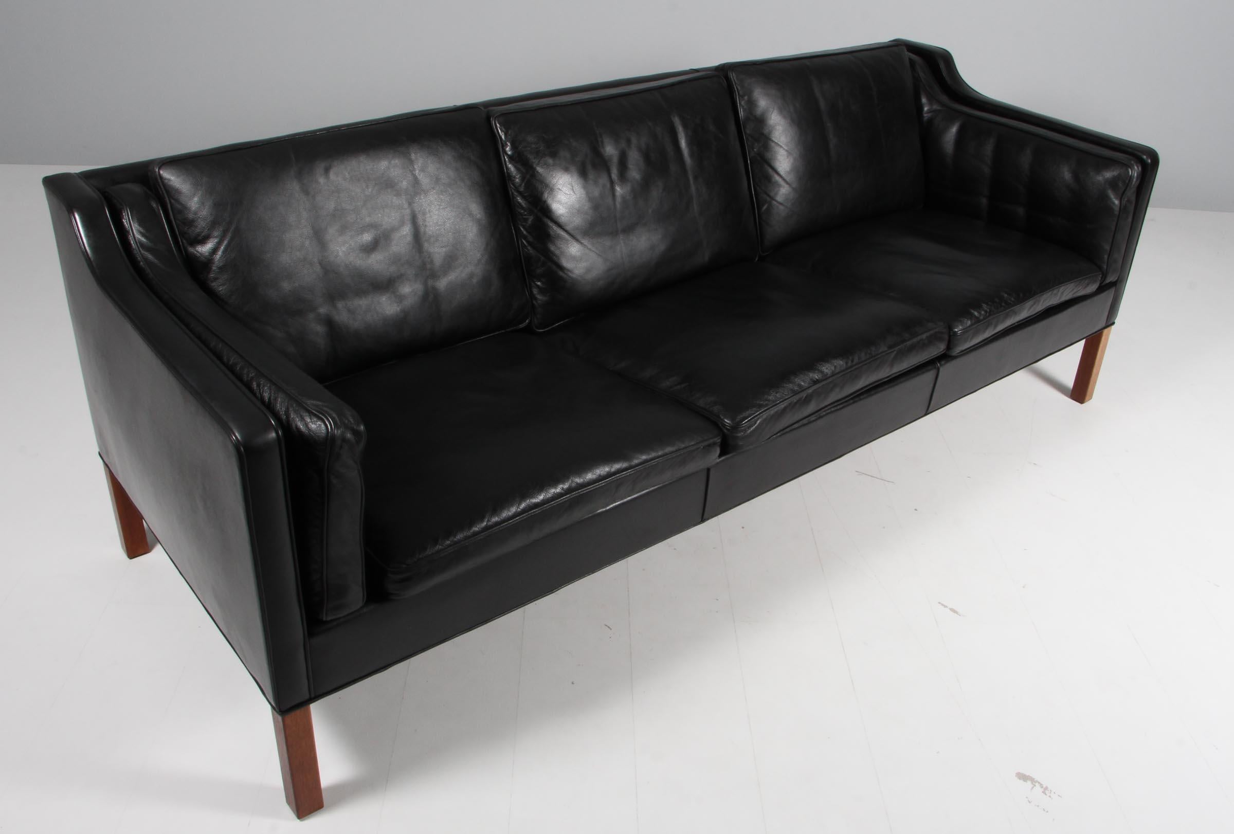 Børge Mogensen three-seat sofa with original patinated black leather upholstery.

Legs of teak.

Model 2213, made by Fredericia Furniture.