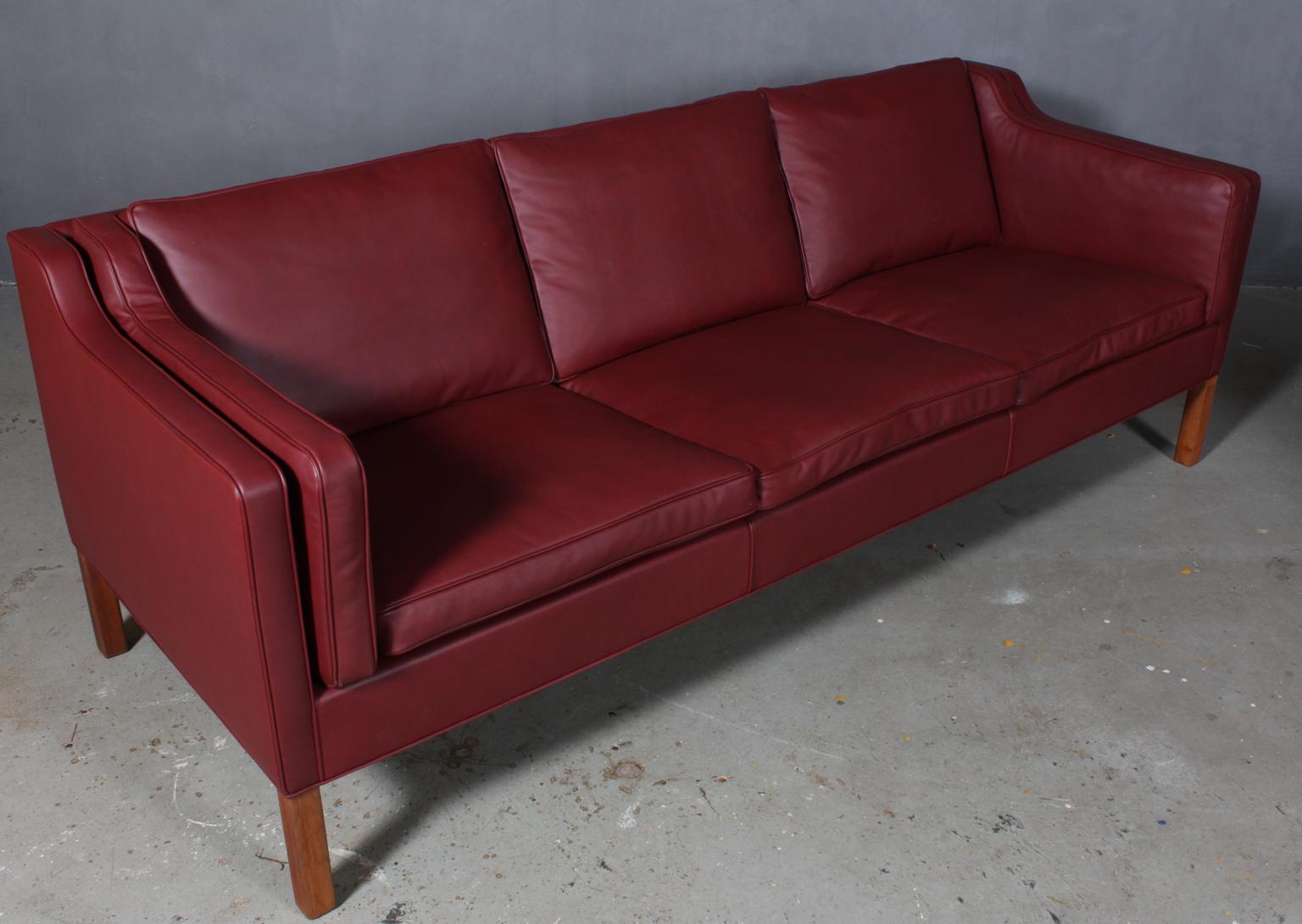 Børge Mogensen three-seat sofa new upholstered with Indian red elegance aniline leather.

Legs of teak.

Model 2213, made by Fredericia Furniture.