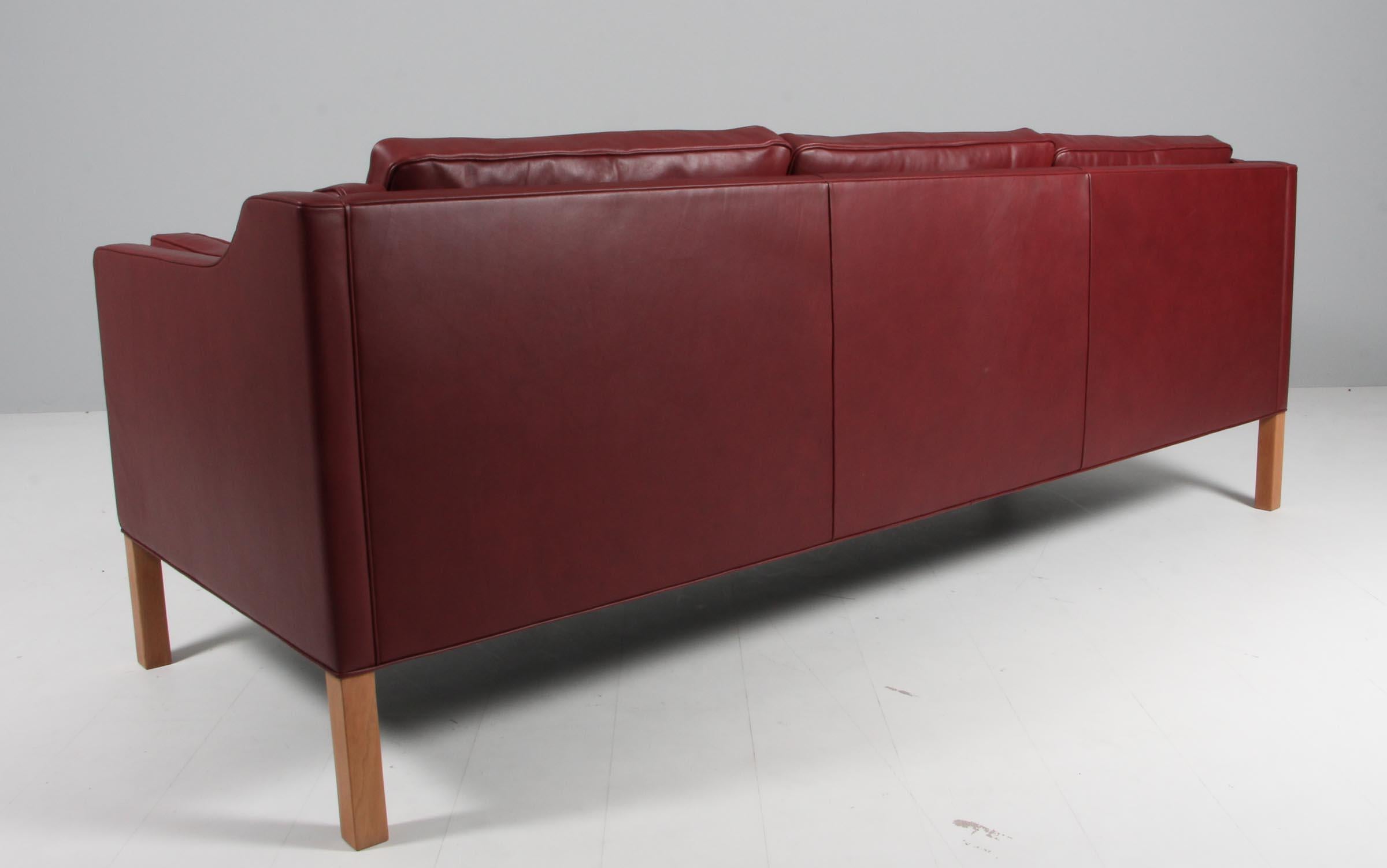 Børge Mogensen three-seat sofa new upholstered with Indian red elegance aniline leather.

Legs of teak.

Model 2213, made by Fredericia Furniture.