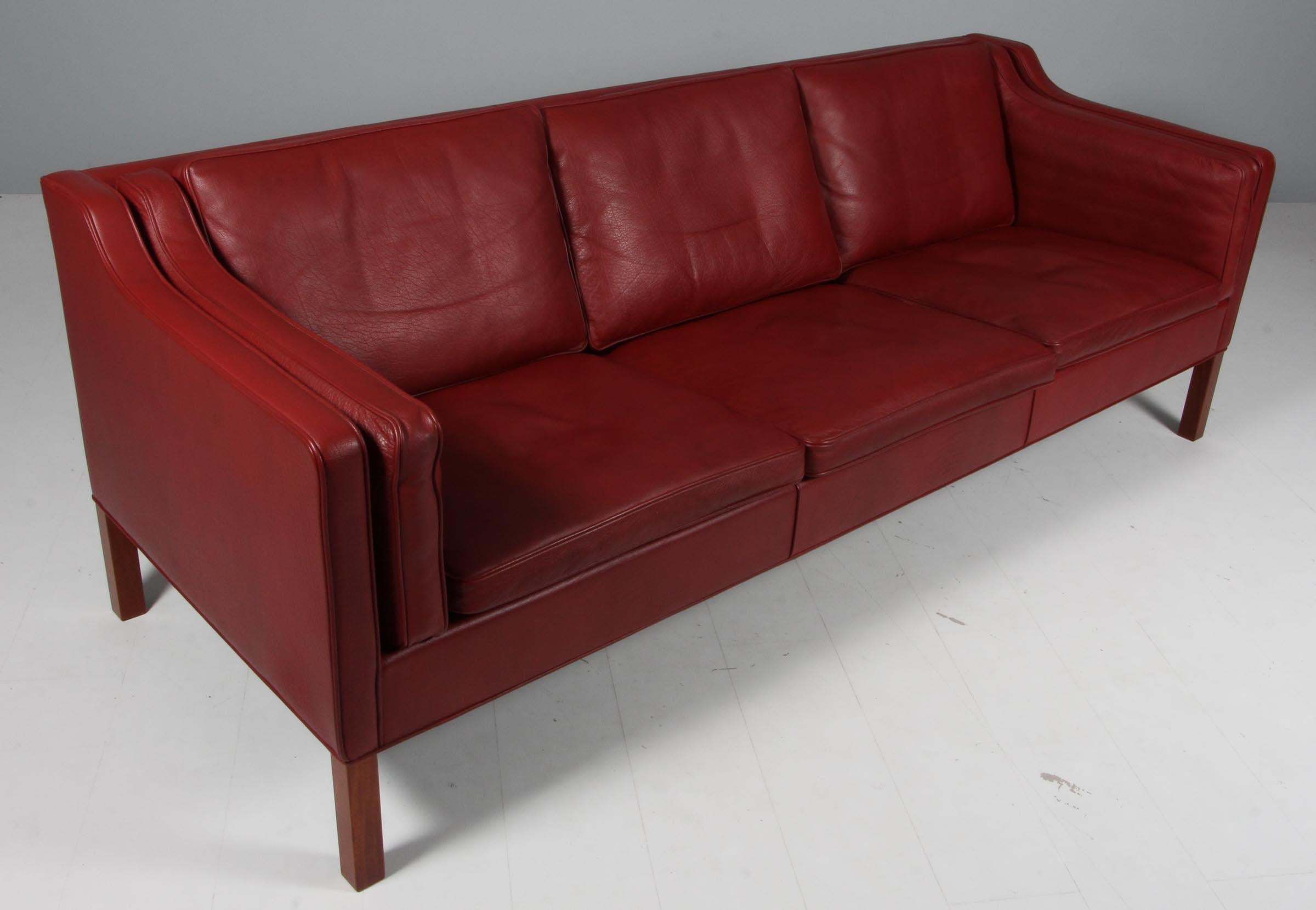 Børge Mogensen three-seat sofa with original patinated red leather upholstery.

Legs of mahogany.

Model 2213, made by Fredericia Furniture.

