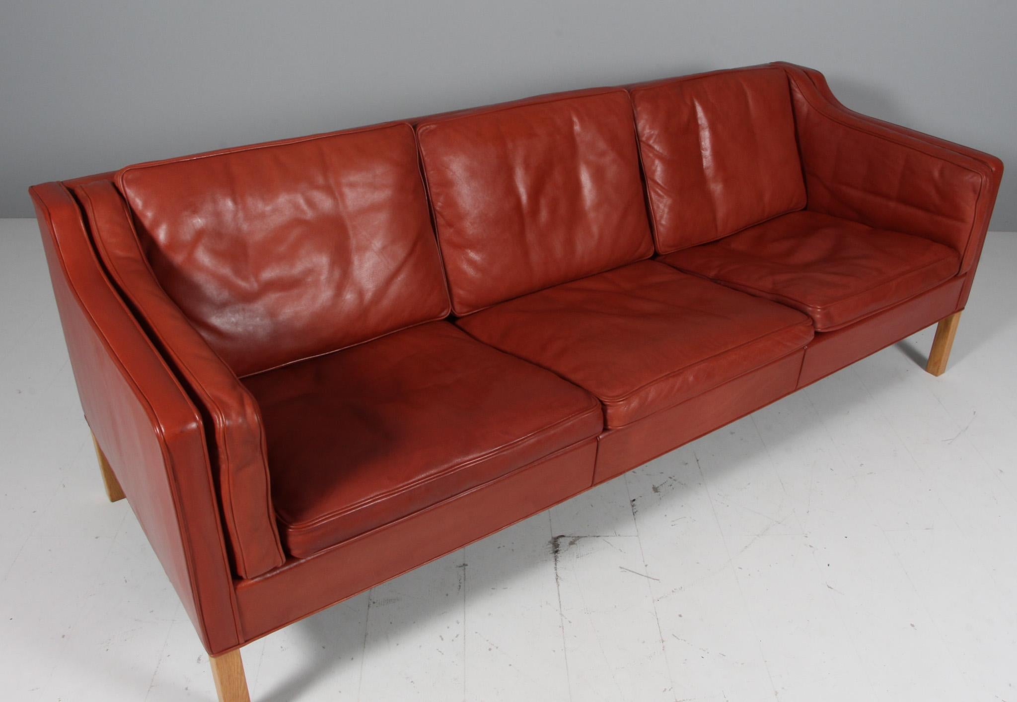 Børge Mogensen three-seat sofa with original patinated red leather upholstery.

Legs of oak.

Model 2213, made by Fredericia Furniture.

Matching two seater

