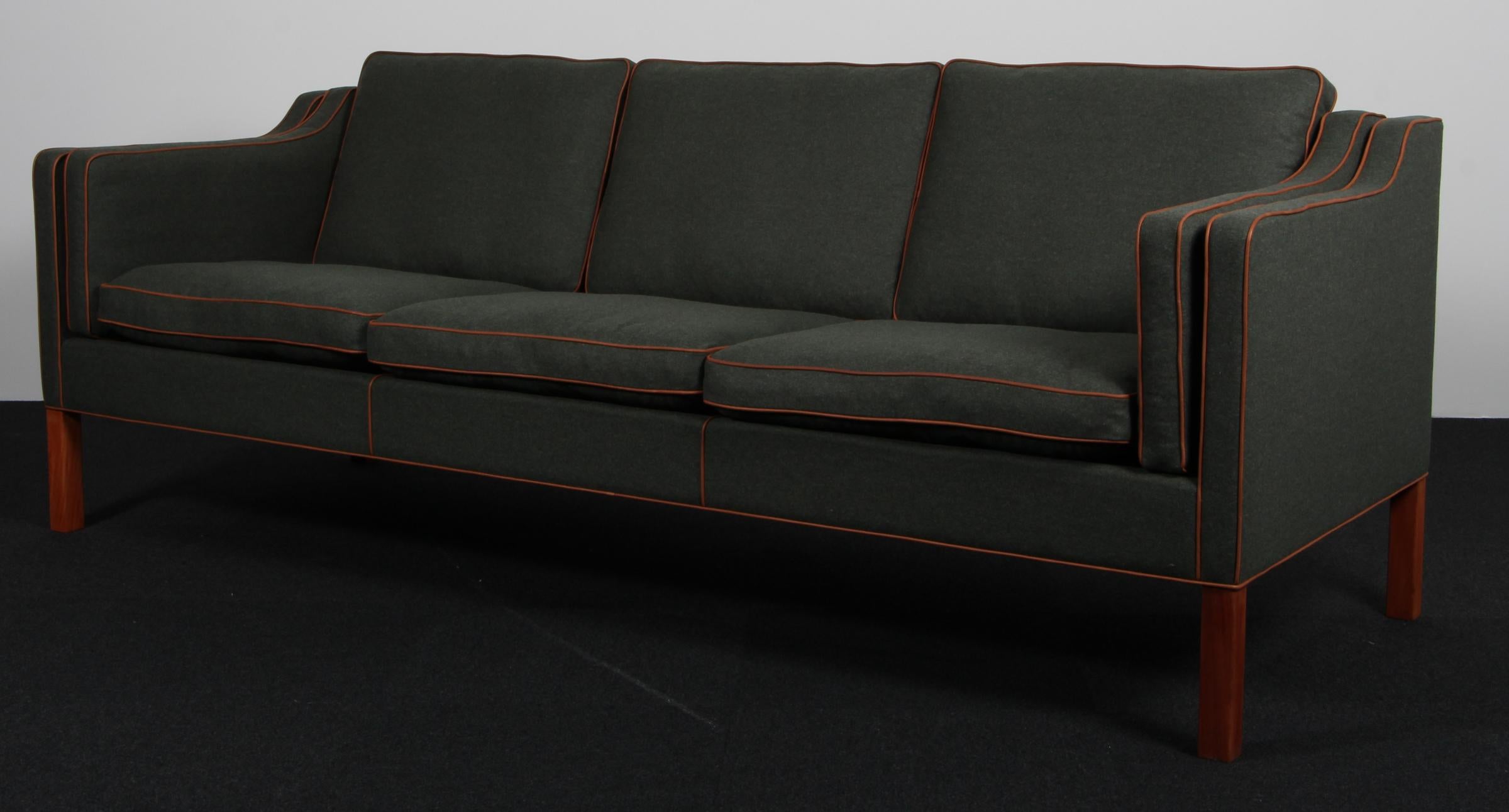 Børge Mogensen three-seat sofa new upholstered with cognac aniline leather and green magrethe wool fabric.

Legs of teak.

Model 2213, made by Fredericia Furniture.