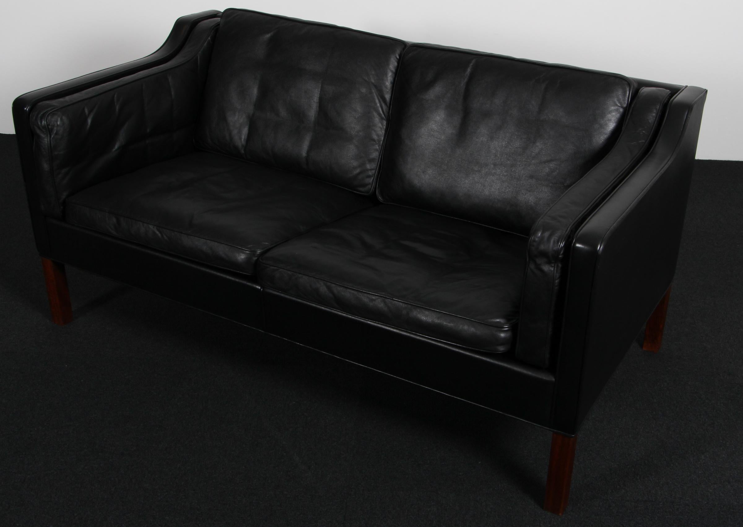 Børge Mogensen two-seat sofa with original black leather upholstery.

Legs of teak.

Model 2212, made by Fredericia Furniture.


