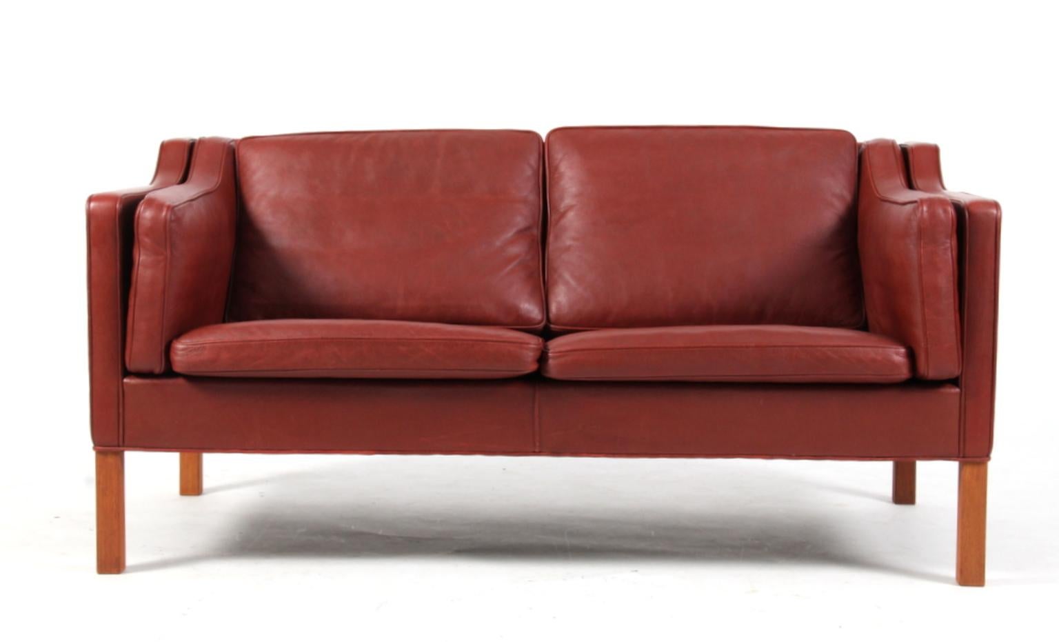 Børge Mogensen two-seat sofa with original Indian red leather upholstery.

Legs of mahogany.

Model 2212, made by Fredericia Furniture.