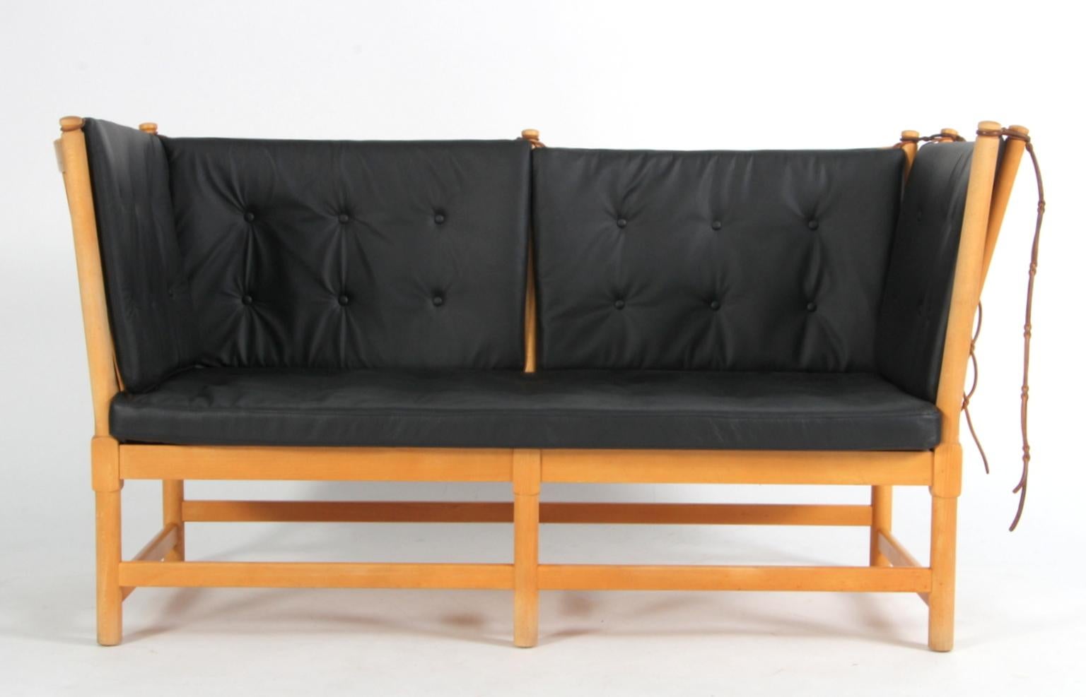 Børge Mogensen two-seat sofa in beech and new cushion set of black leather.

Model tremmesofa (1789), made by Fritz Hansen.