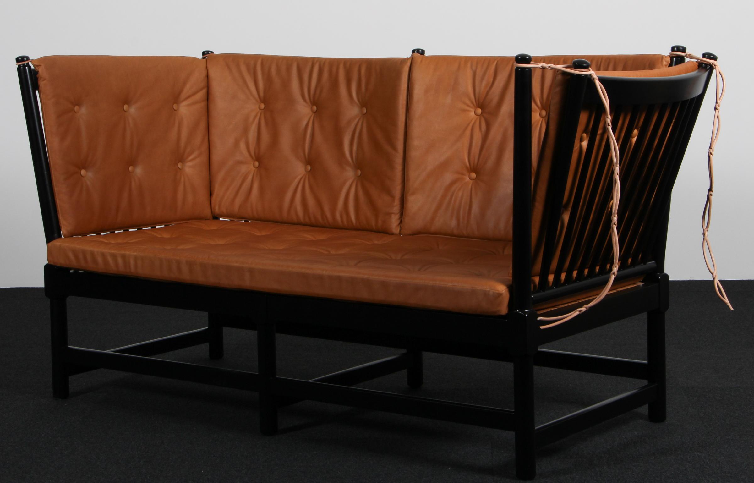 Sofá Børge Mogensen de dos plazas en haya lacada en negro y nuevos cojines tapizados en piel de anilina vintage coñac.

Modelo tremmesofa (1789), fabricado por Fritz Hansen.