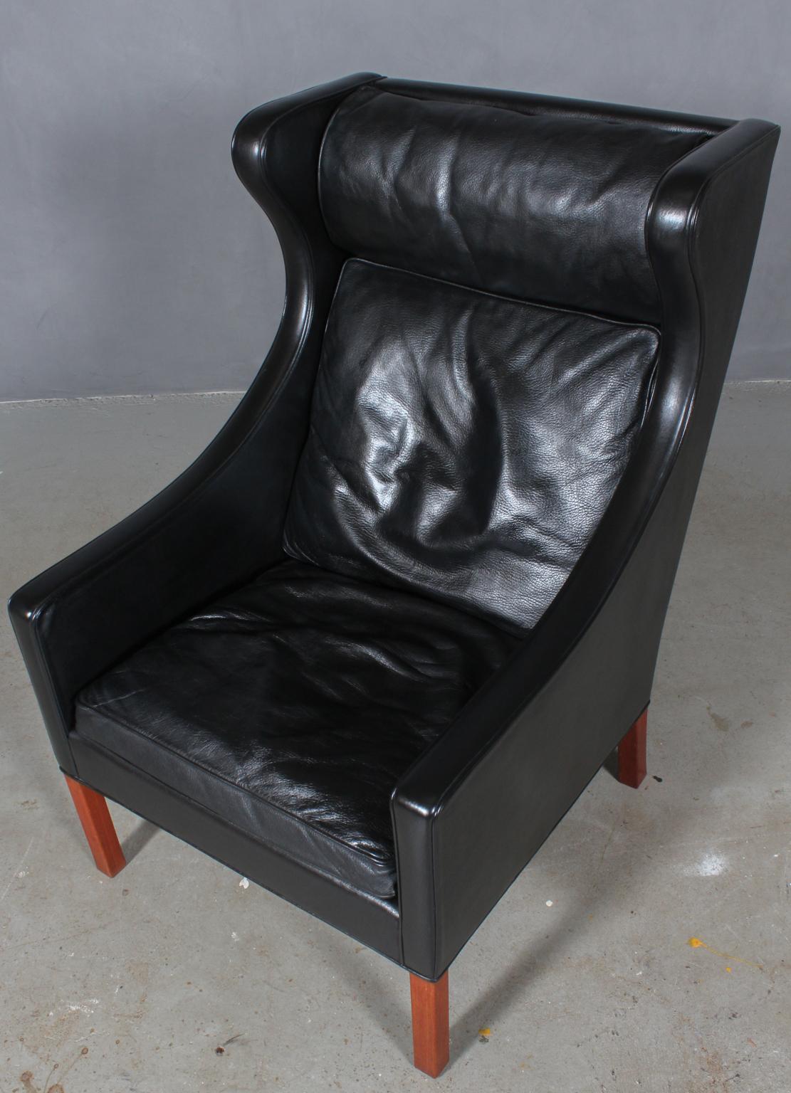 Børge Mogensen wingback chair in original black patinated leather upholstery.

Legs in mahogany.

Model 2204, made by Fredericia Furniture.