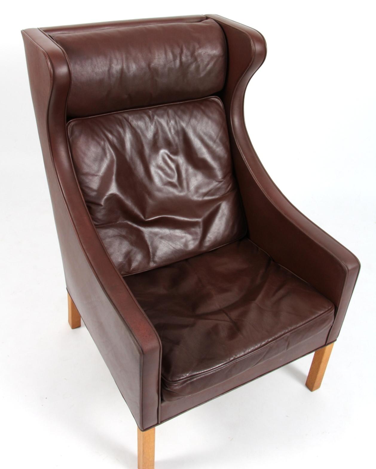 Børge Mogensen wing back chair in original brown patinated leather upholstery.

Legs in oak.

Model 2204, made by Fredericia Furniture.

 