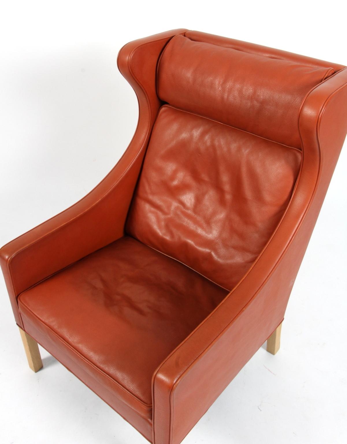 Børge Mogensen wing back chair in original cognac patinated leather upholstery.

Legs in oak.

Model 2204, made by Fredericia Furniture.