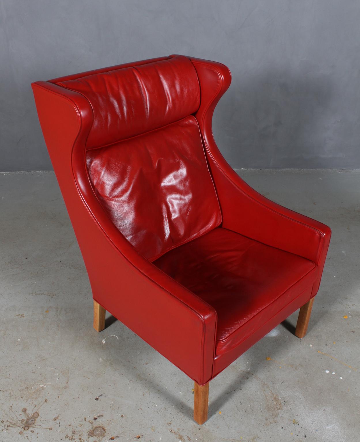Børge Mogensen wingback chair in original red patinated leather upholstery.

Legs in oak.

Model 2204, made by Fredericia Furniture.