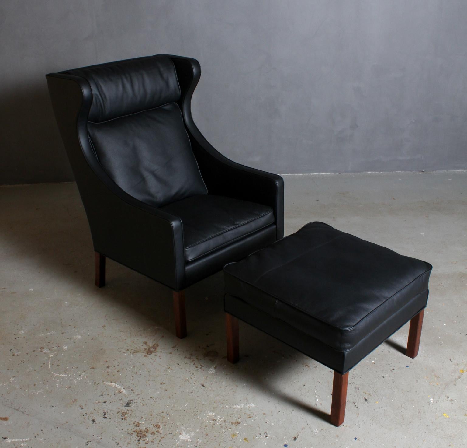 Børge Mogensen wingback chair and ottoman new upholstered with black leather.

Legs of mahogany.

Model 2202 and 2204, made by Fredericia Furniture.