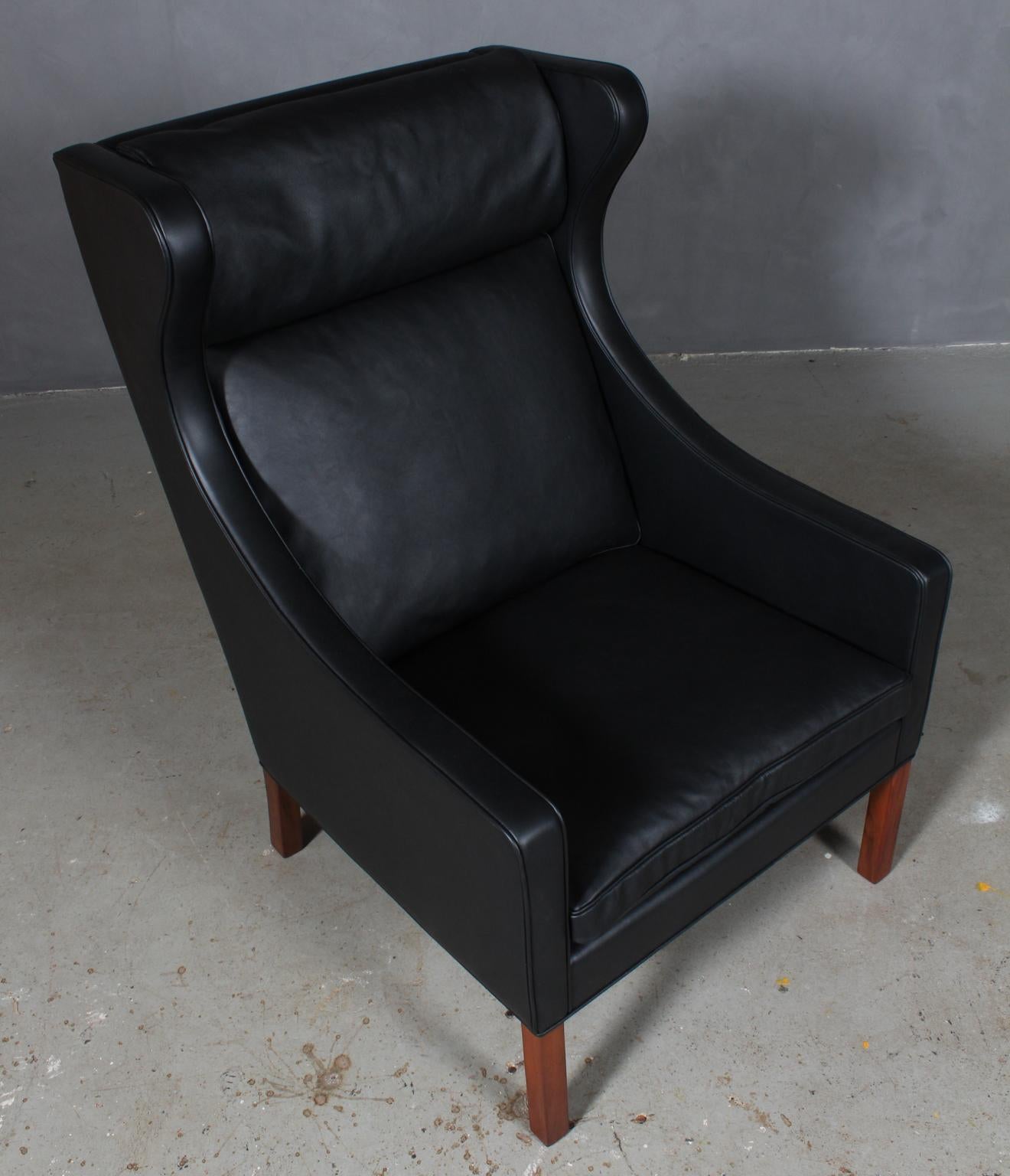 Børge Mogensen wingback chair new upholstered with black elegance leather.

Legs in teak.

Model 2204, made by Fredericia Furniture.